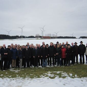 Landrat Stefan Rößle mit der Delegation vor den Windrädern auf Wildpoldsrieder Flur. Foto: LRA Donau-Ries.