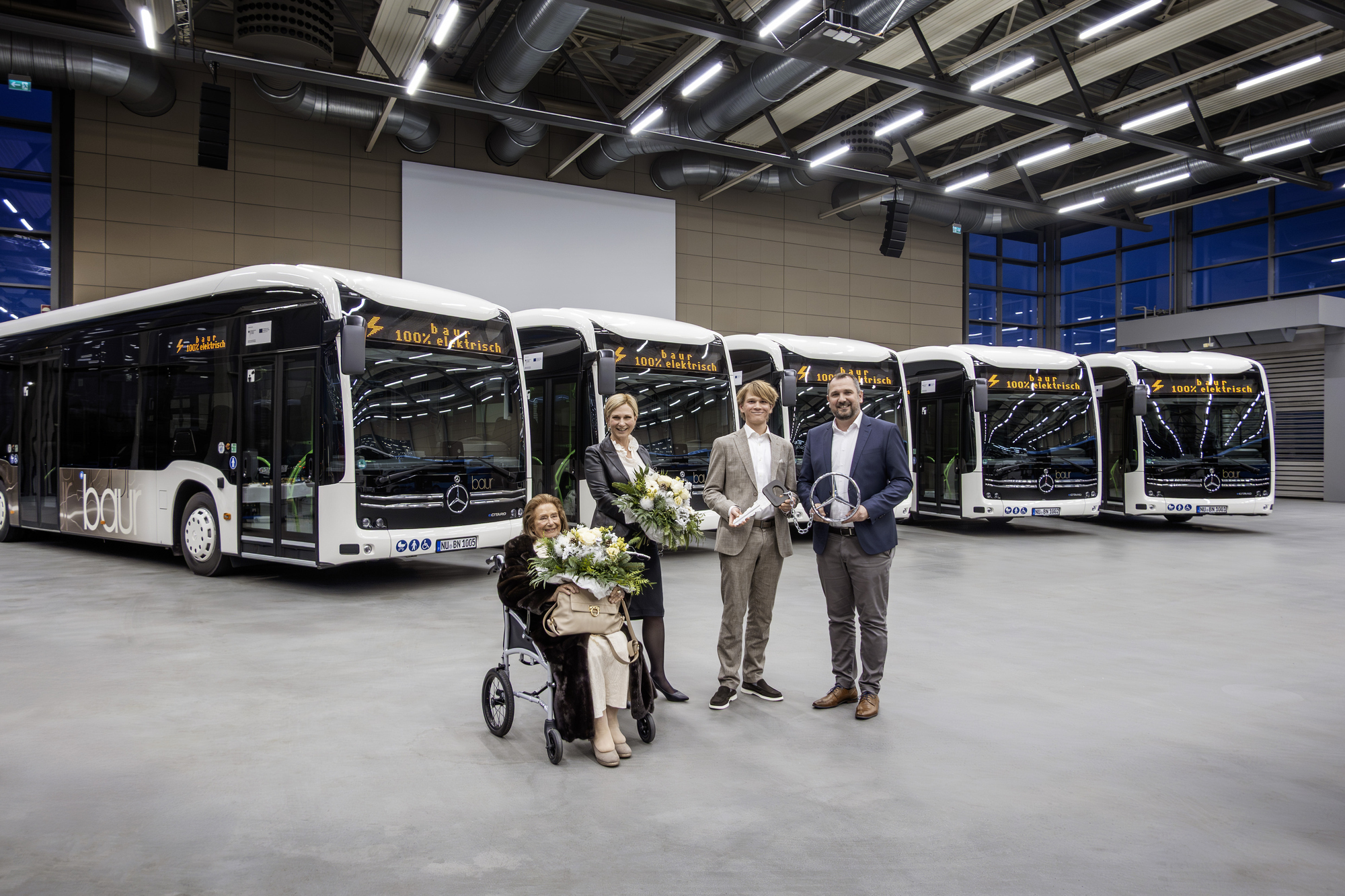 Fünf neue Mercedes-Benz eCitaro hat die Omnibus Weidachstein GmbH &amp; Co. KG am 16. Dezember 2025 im Daimler Buses Omnibuswerk in Neu-Ulm in Empfang genommen. (v.l.n.r.): Hildegard Schnarrenberger, Omnibus Weidachstein GmbH &amp; Co. KG, Dr. Sandra Bayerle-Schnarrenberger, Inhaberin der Omnibus Weidachstein GmbH &amp; Co. KG mit Sohn Kilian Benedikt Bayerle, sowie Marijo Sapina, Leiter Vertrieb Privatkunden bei Daimler Buses. Foto: Daimler Truck AG