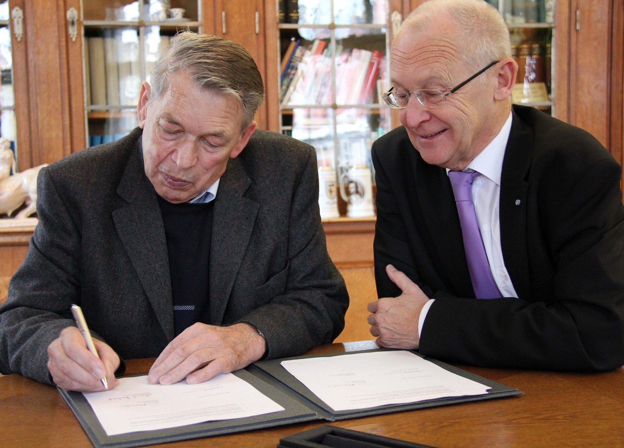 Benningens Bürgermeister Meinrad Bernhard setzt seine Unterschrift unter den Vertrag Foto: Stadt Memmingen