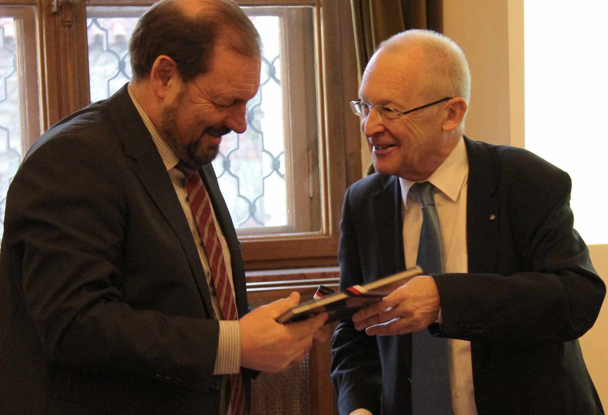 OB Dr. Ivo Holzinger überreicht Landrat Heinz Seiffert, zur Begrüßung ein Buch-Präsent. Foto: La Rossa/Stadt Memmingen