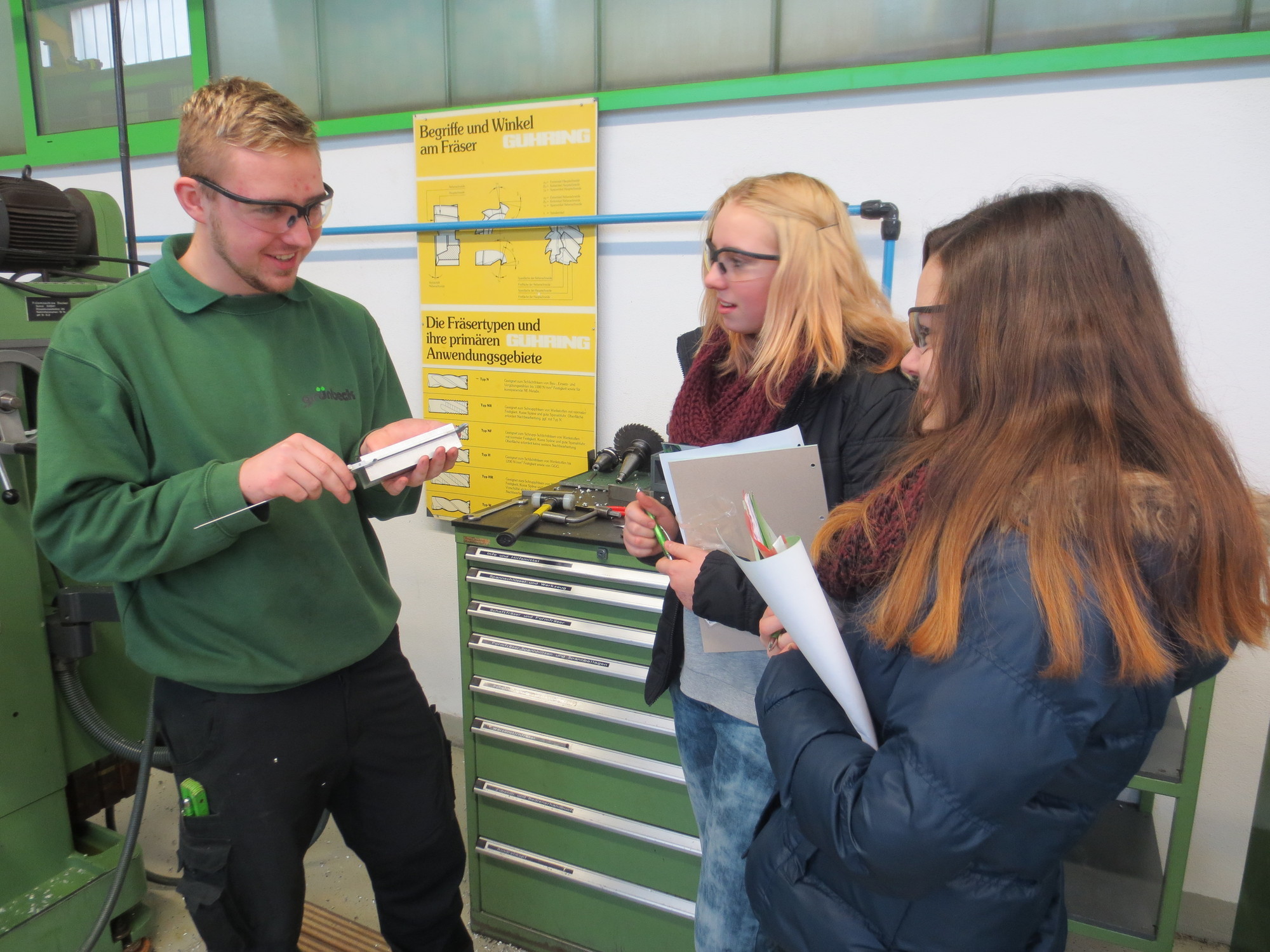 Der Auszubildende Dominik Körle erklärt den Schülerinnen Tamara und Vivien den Messschieber. Foto: Grünbeck