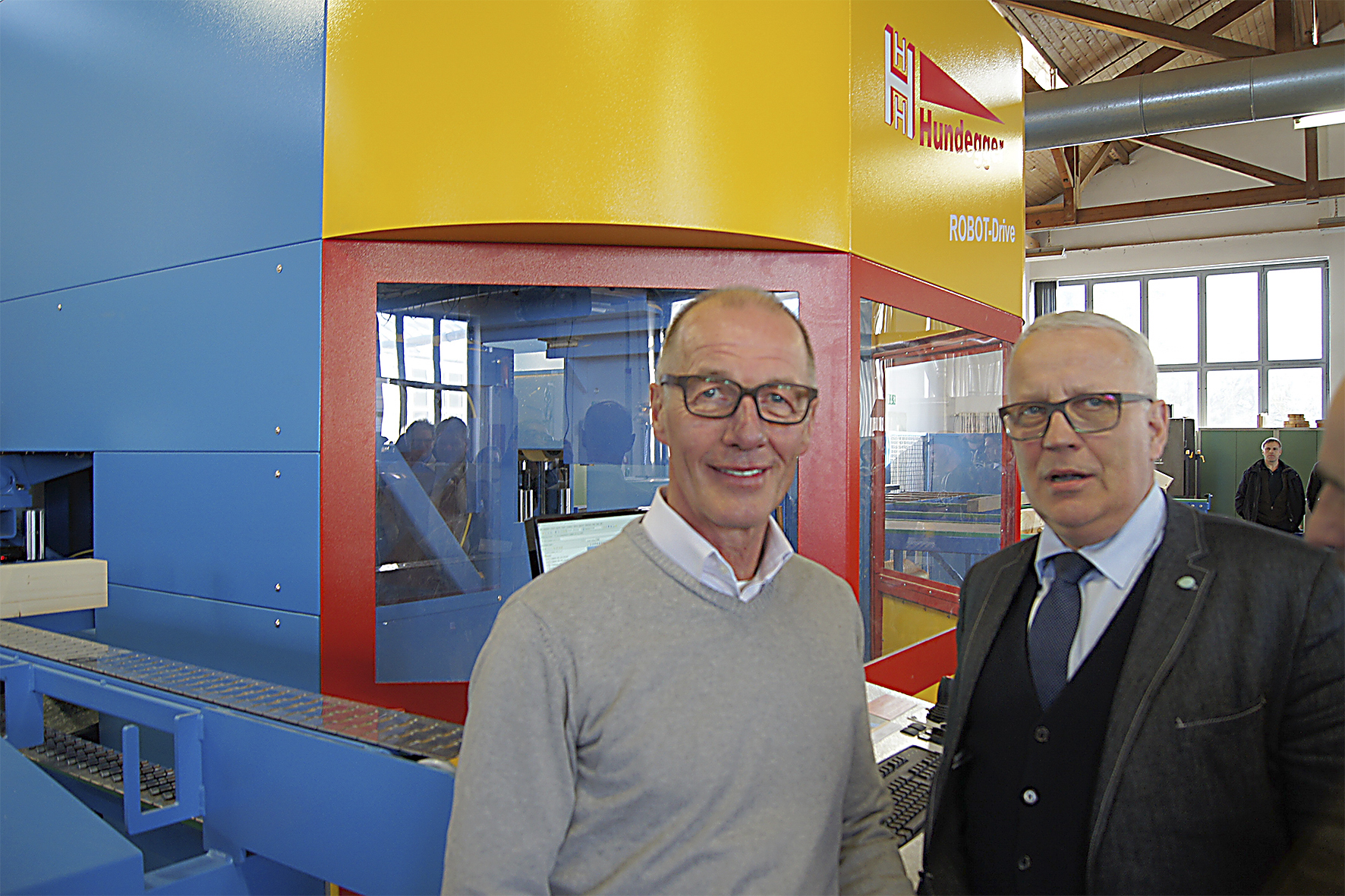 Hans Hundegger (li.) bei der Übergabe der neuen Maschine. Foto: Hans Hundegger AG
