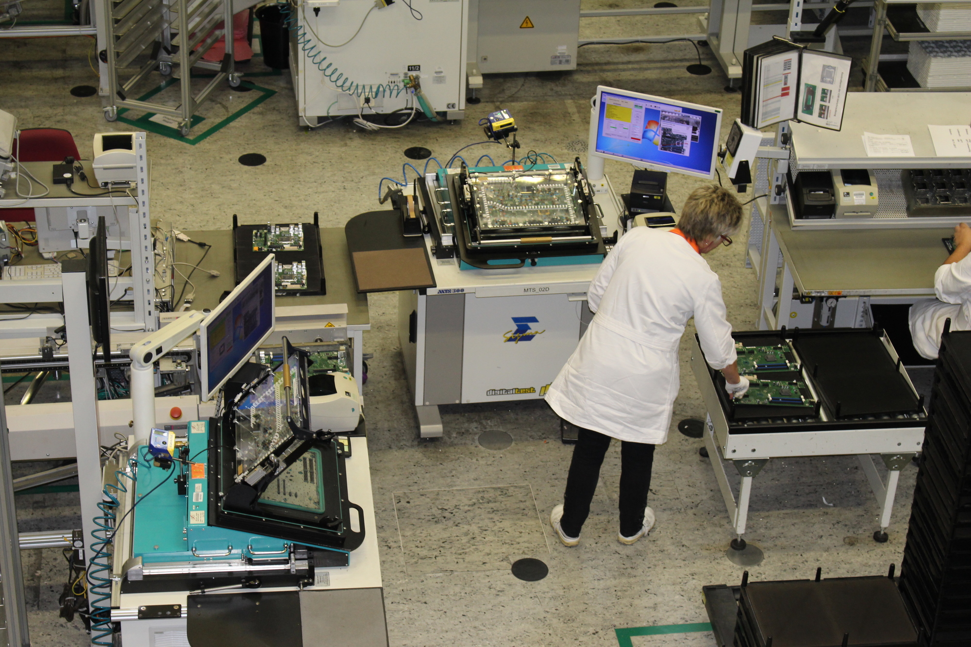 Hier werden die Mainboards getestet. An dieser Station erhalten die Mitarbeiter ab Januar Unterstützung durch die beiden Roboterarme.