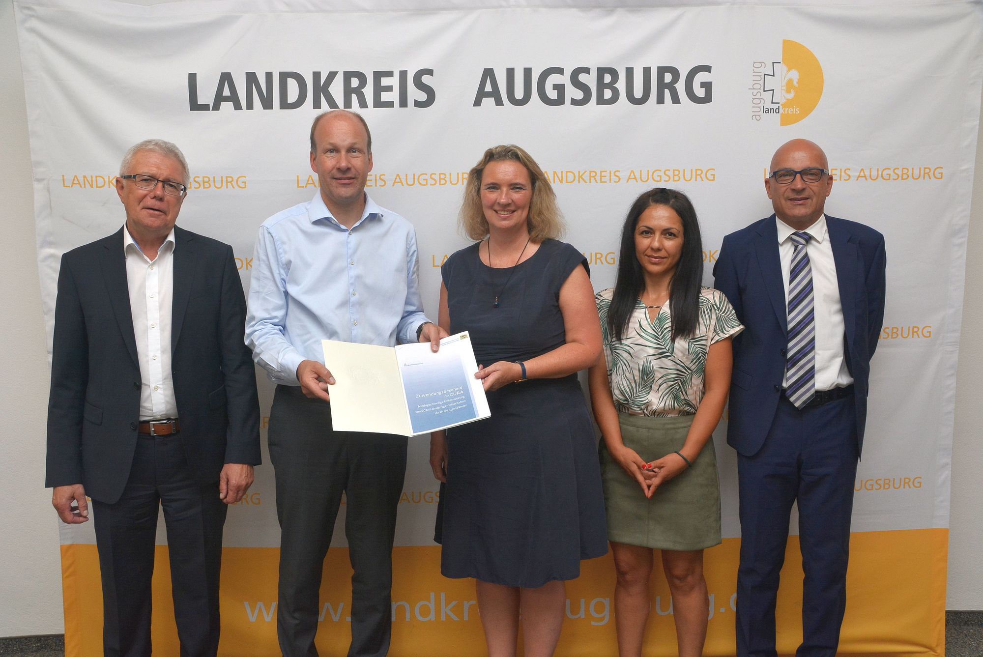 Staatsministerin Kerstin Schreyer (Mitte) übergibt Landrat Martin Sailer (2.v.l.) den CURA-Förderbescheid. Foto: Landratsamt Augsburg.
