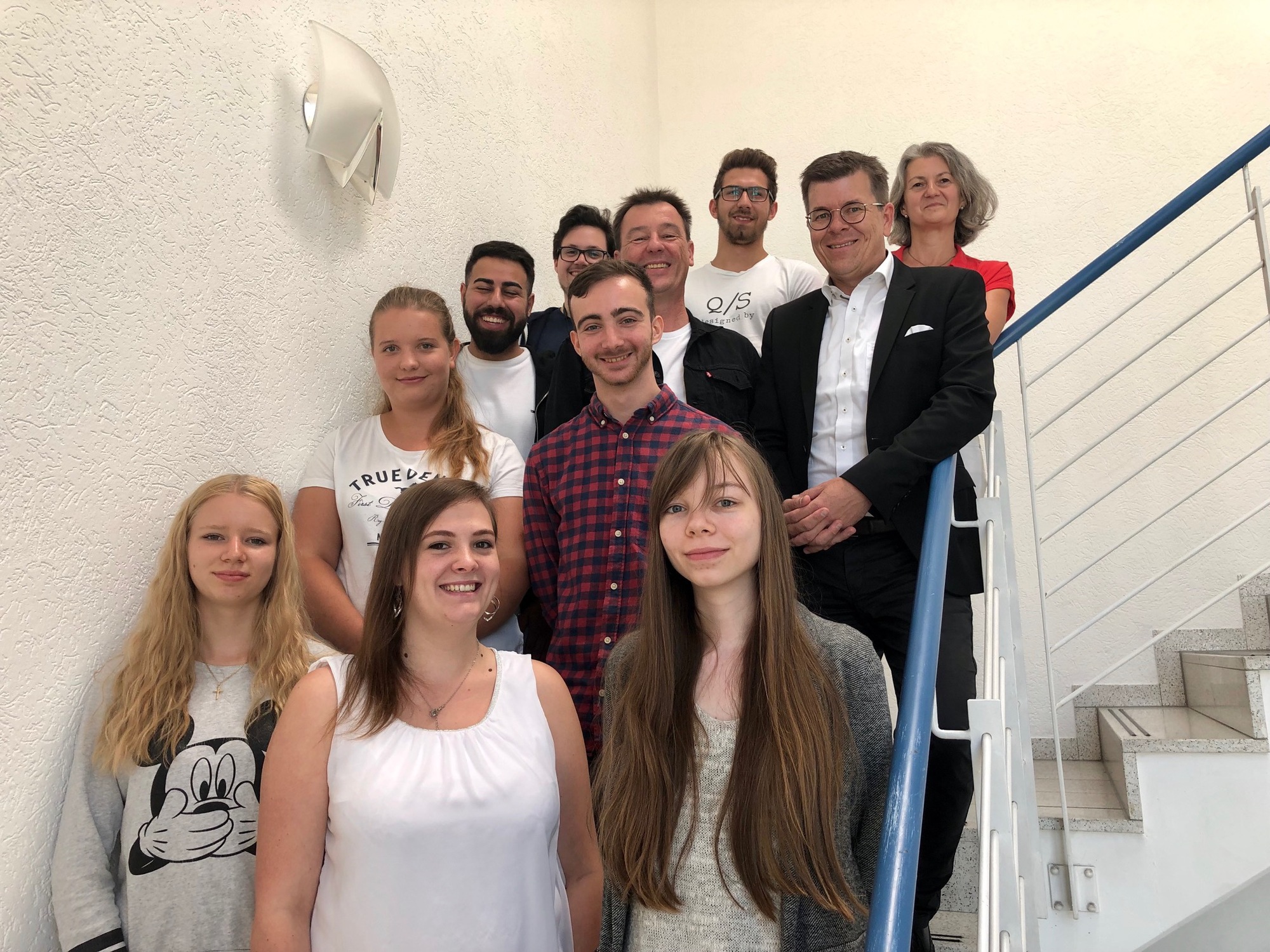 CEO Christian Sailer, Betriebsratsvorsitzender Timm Bossmann und Ausbildungsbeauftragte Irene Marquardt mit den neuen Azubis. Foto (Abdruck honorarfrei mit Copyright @Weltbild)