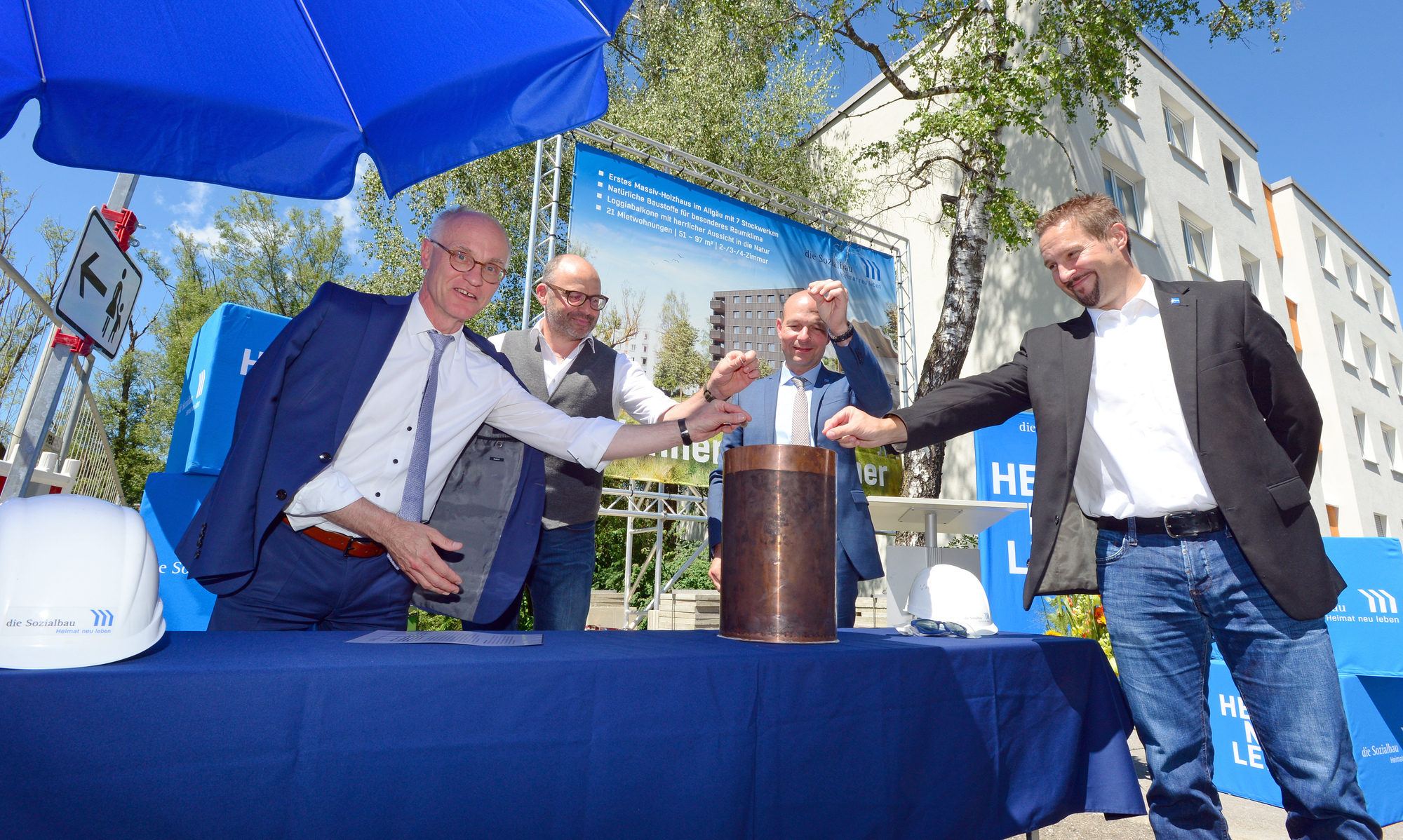 Den Kupferzylinder für die Grundsteinlegung befüllten von links: Sozialbau-Chef Herbert Singer, Maximilian Prutscher (Fa. Prutscher Holzbau GmbH), Kemptens Oberbürgermeister Thomas Kiechle und Baureferent Tim Oliver Koemstedt. Foto: Sozialbau Kempten