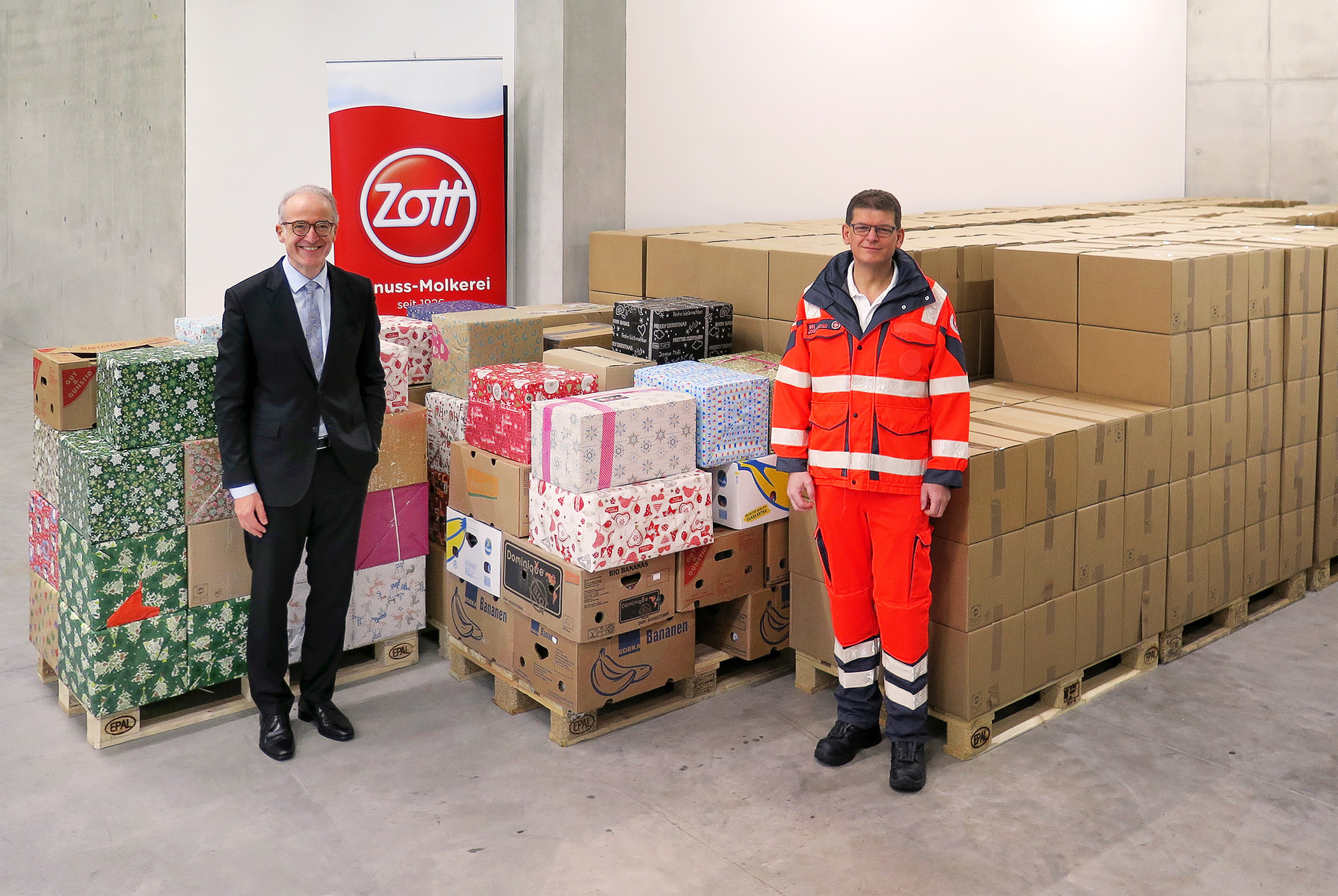 Anton Hammer, Geschäftsführender Direktor Finanzen &amp; Service, übergibt die 624 gespendeten Pakete an Markus Kristen von den Johannitern. Foto: Zott