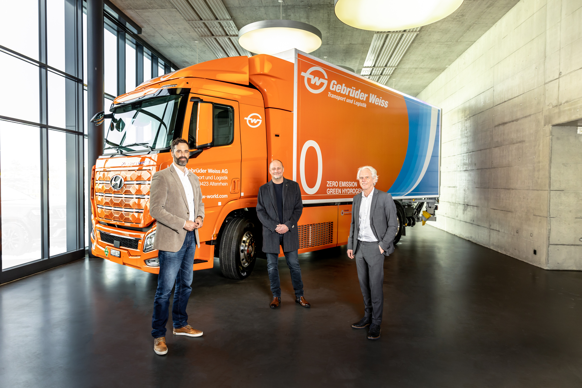 Bei der Übergabe des Wasserstoff-Lkw in Rothenburg, Schweiz (v.l.): Marc Freymüller, CEO Hyundai Hydrogen Mobility AG, Peter Waldenberger, Leiter Corporate Administrative Support, und Oskar Kramer, Landesleiter Schweiz (beide Gebrüder Weiss). Foto: Gebrüder Weiss / Stefan Peter