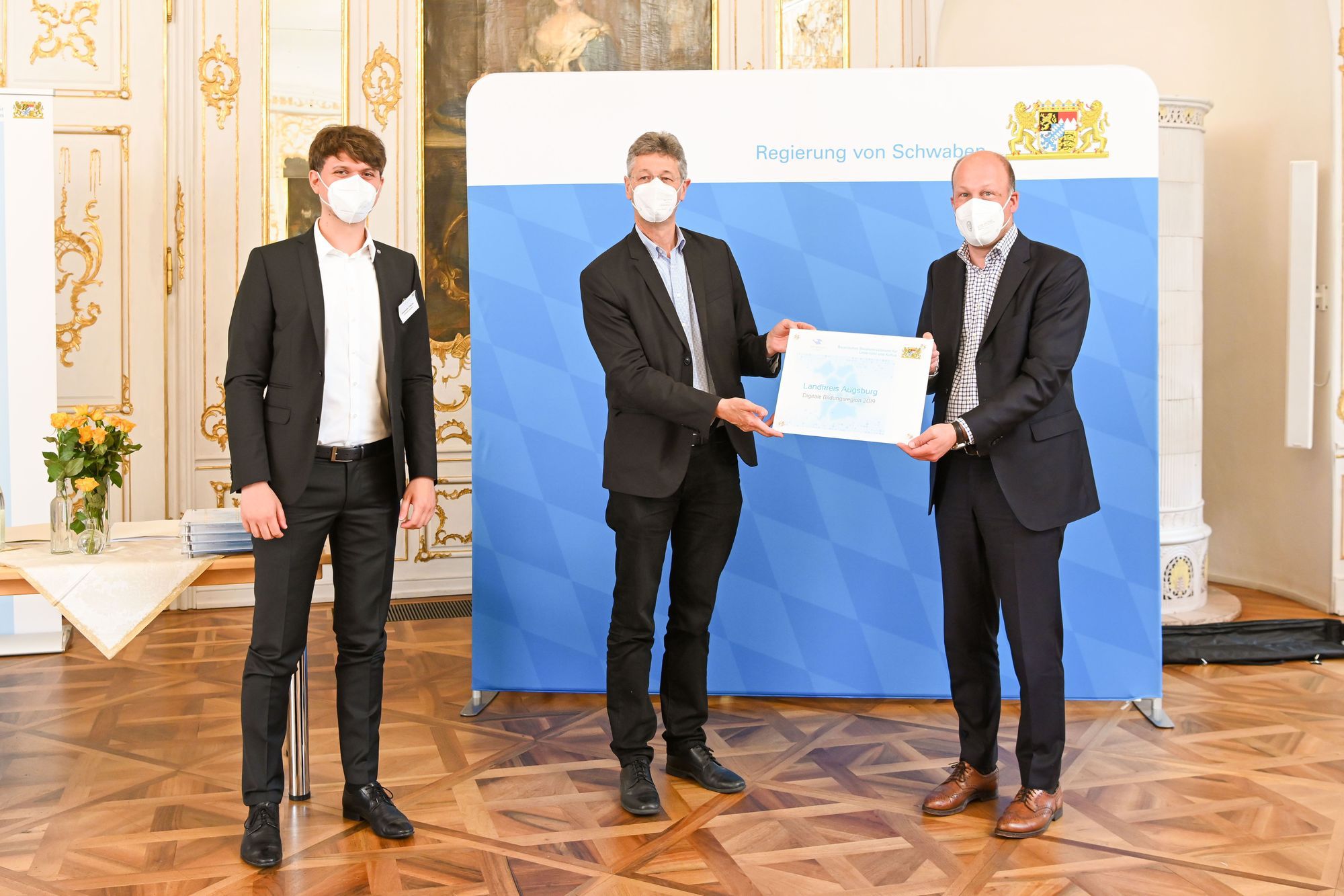 Der Bayerische Kultusminister Michael Piazolo (Mitte) überreichte Landrat Martin Sailer (rechts) und Alexander Piecha das Qualitätssiegel „Digitale Bildungsregion“. Foto: LRA Augsburg