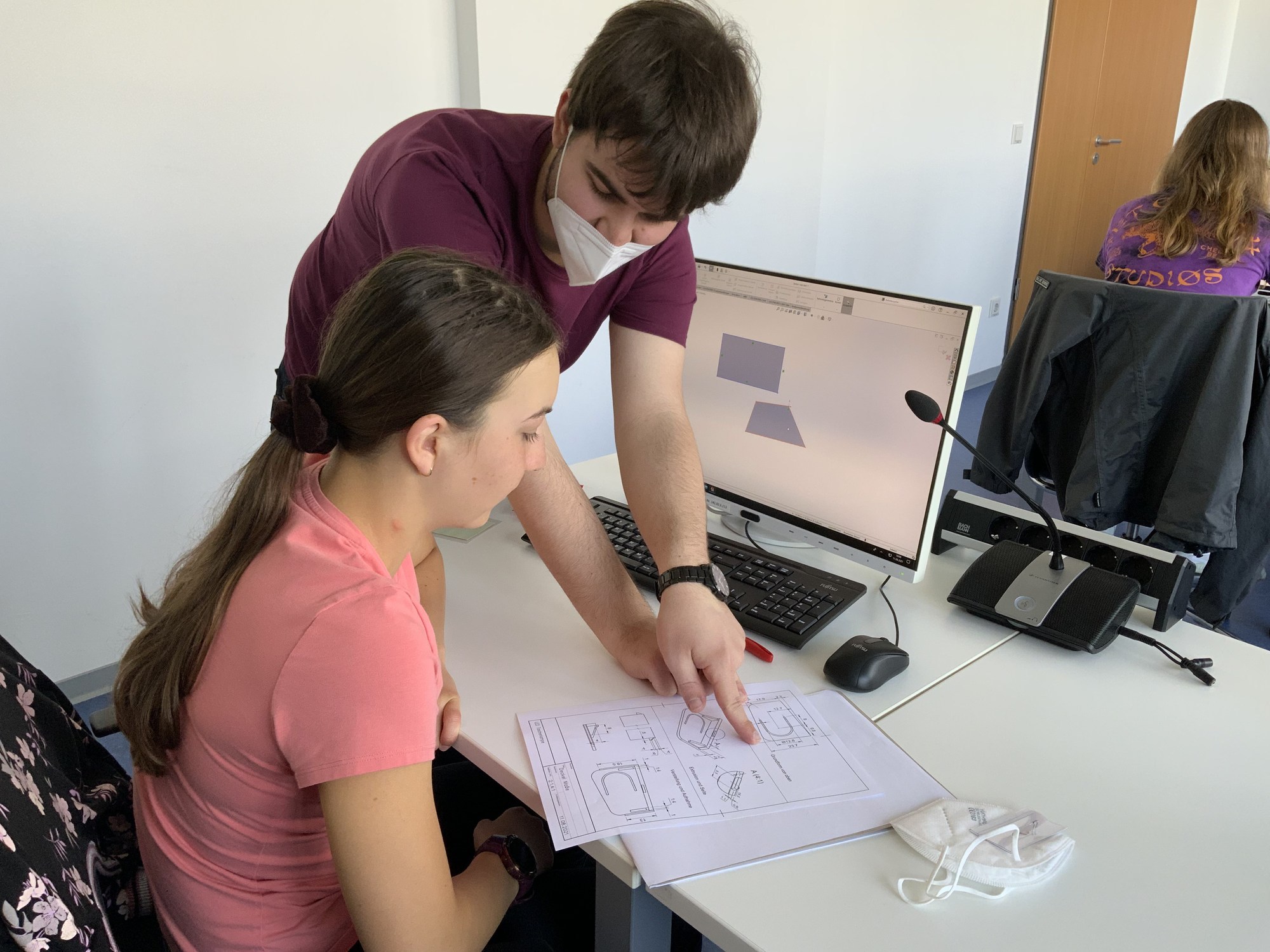 Franz Thanner (Hochschule Augsburg) erklärt der Teilnehmerin Lena die Bauanleitung für einen LED-Beleuchteten Schlüsselanhänger. Foto: Jacqueline Klemm