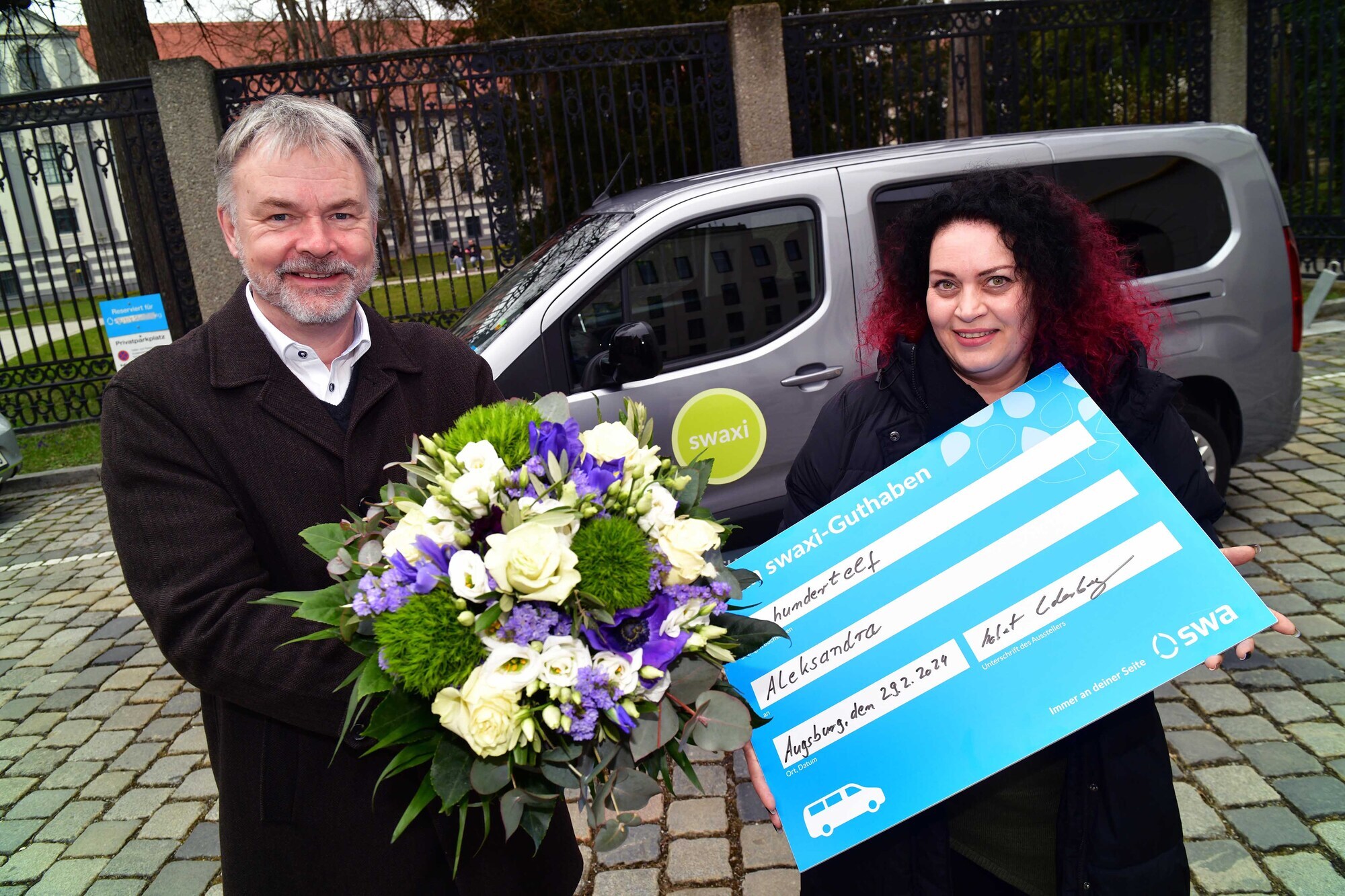 Robert Underberg, Leiter der Mobilitätsentwicklung bei den swa überreicht der 11.111 swaxi-Kundin Aleksandra Sucur einen swaxi-F