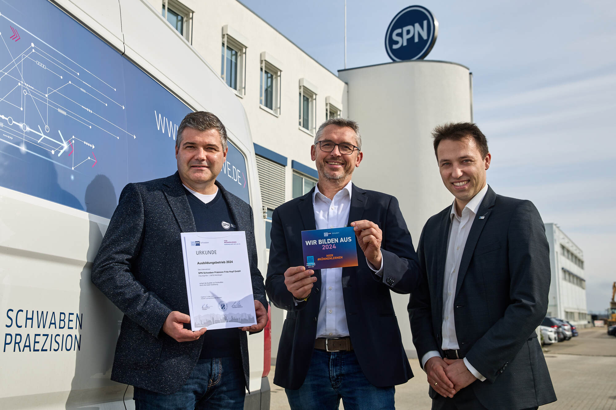 Von links: Jürgen Sieber, Rainer Hertle, und IHK Regionalgeschäftsführer Matthias Hausmann mit Urkunde und Aufkleber vor dem Fir