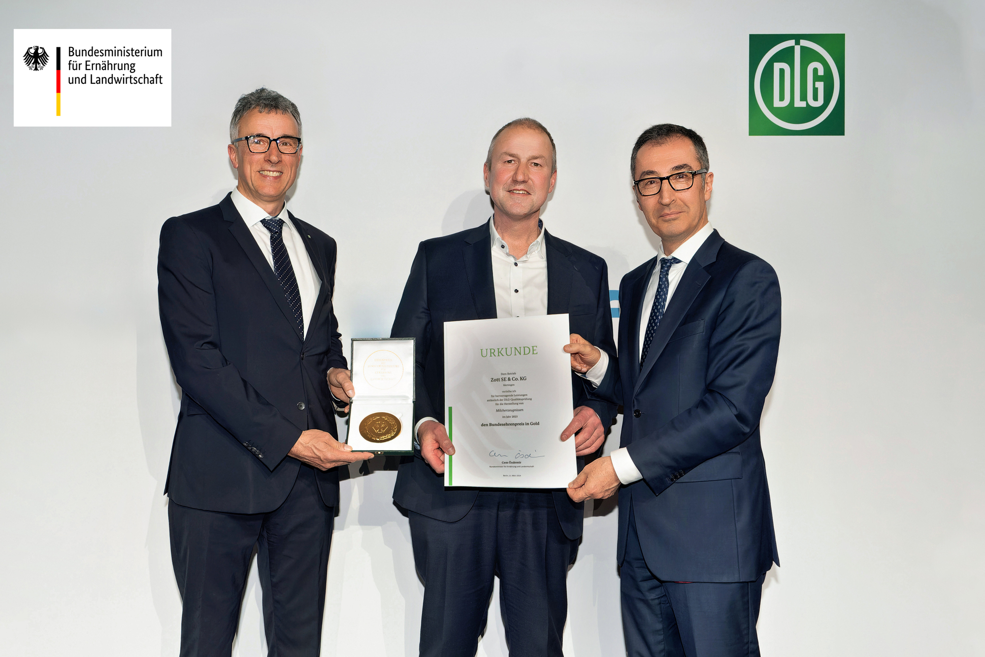 Bundesminister Cem Özdemir überreicht Urkunde gemeinsam mit DLG-Vizepräsident René Döbelt auf dem 14. Berliner Milchforum an Chr