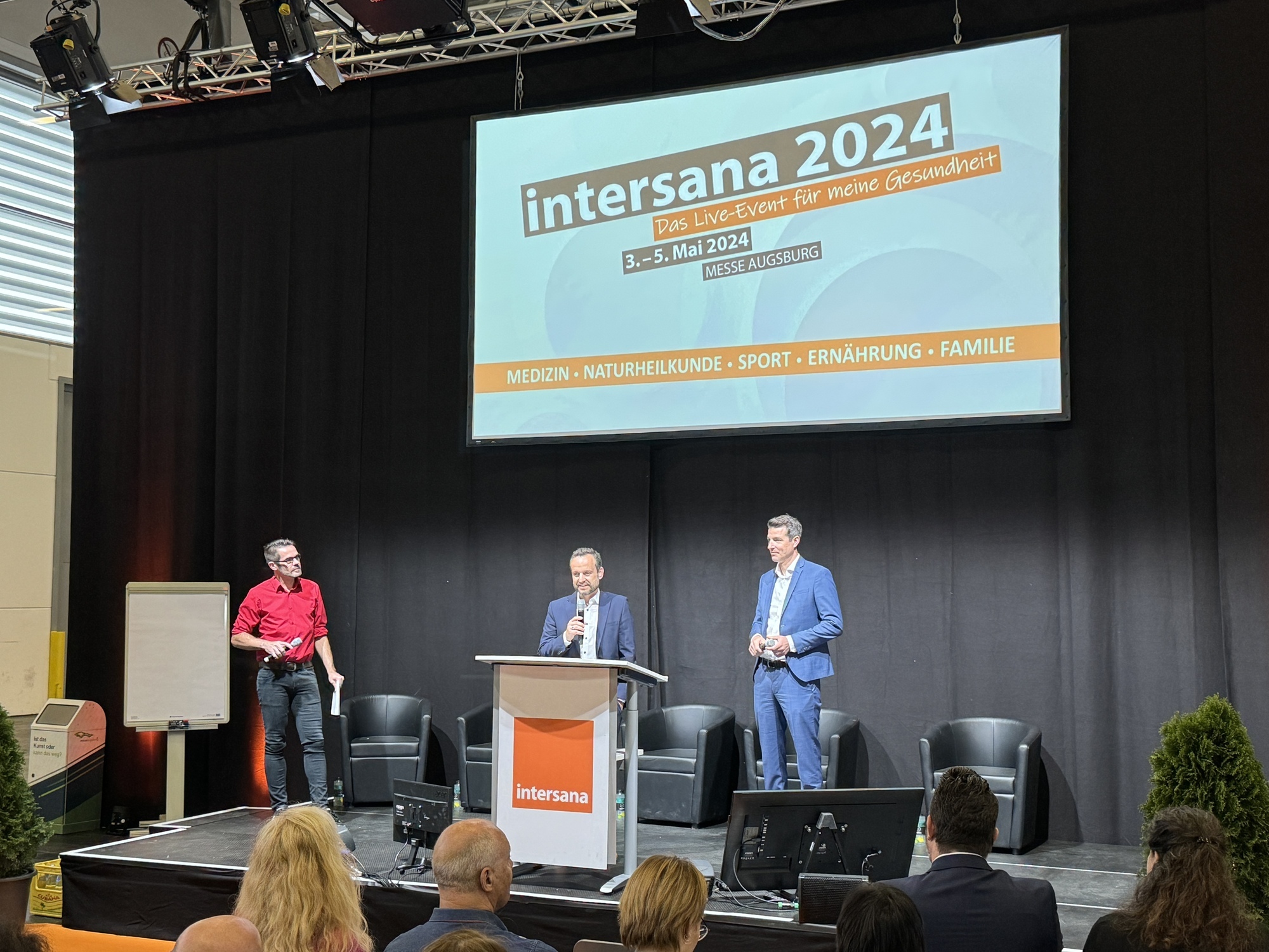 Matthias Schmid, Mitglied der Geschäftsleitung der Augsburger Allgemeinen, (Mitte) und Lorenz A. Rau, Geschäftsführer Messe Augsburg, (rechts) präsentieren die intersana 2024. Foto: Thomas Koristka/B4BSCHWABEN.de