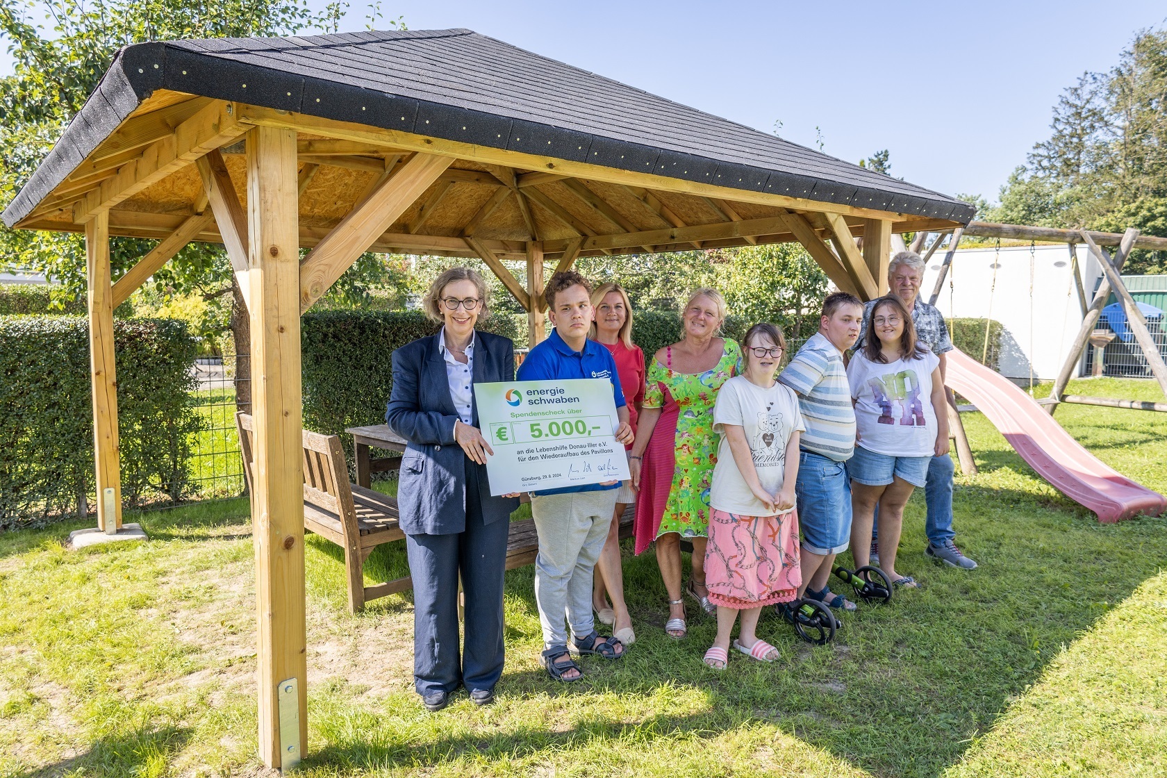 Christine Paul Eger (links) überreichte den Spendencheck für den Pavillon an die Jugend- und Teenie-Gruppe des Lebenshilfe-Zentrums in Günzburg sowie Ekaterina Klug (dritte von links), Roswitza Hempe (vierte von links) und Hans-Jürgen Widmann (rechts). Foto: Energie Schwaben / Kathrin Urbanek