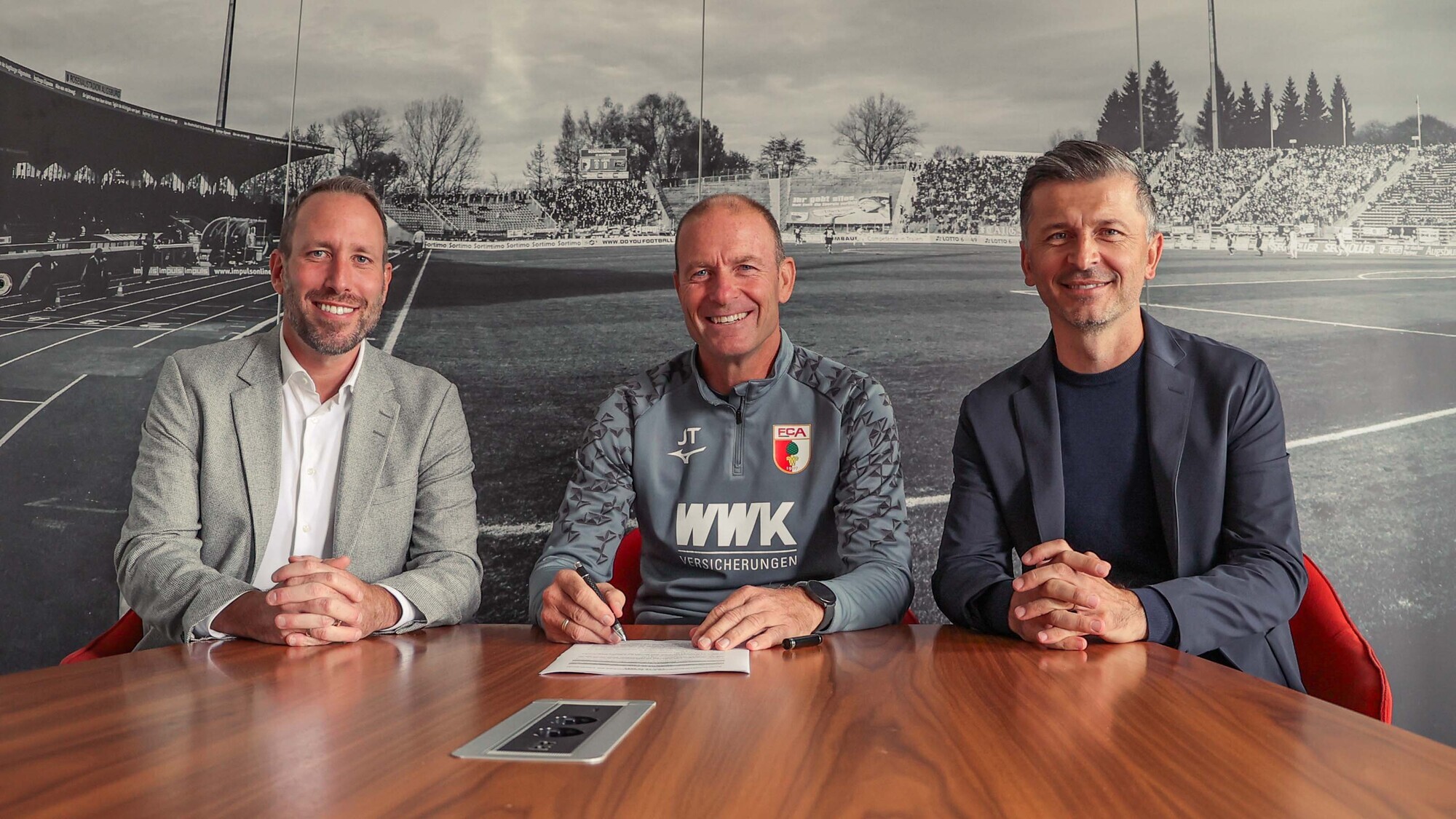 Michael Ströll, Geschäftsführer des FC Augsburg, Jess Thorup, Cheftrainer des FCA, und Marinko Jurendic, FCA-Sportdirektor, bei der Vertragsunterzeichnung. Foto: FC Augsburg