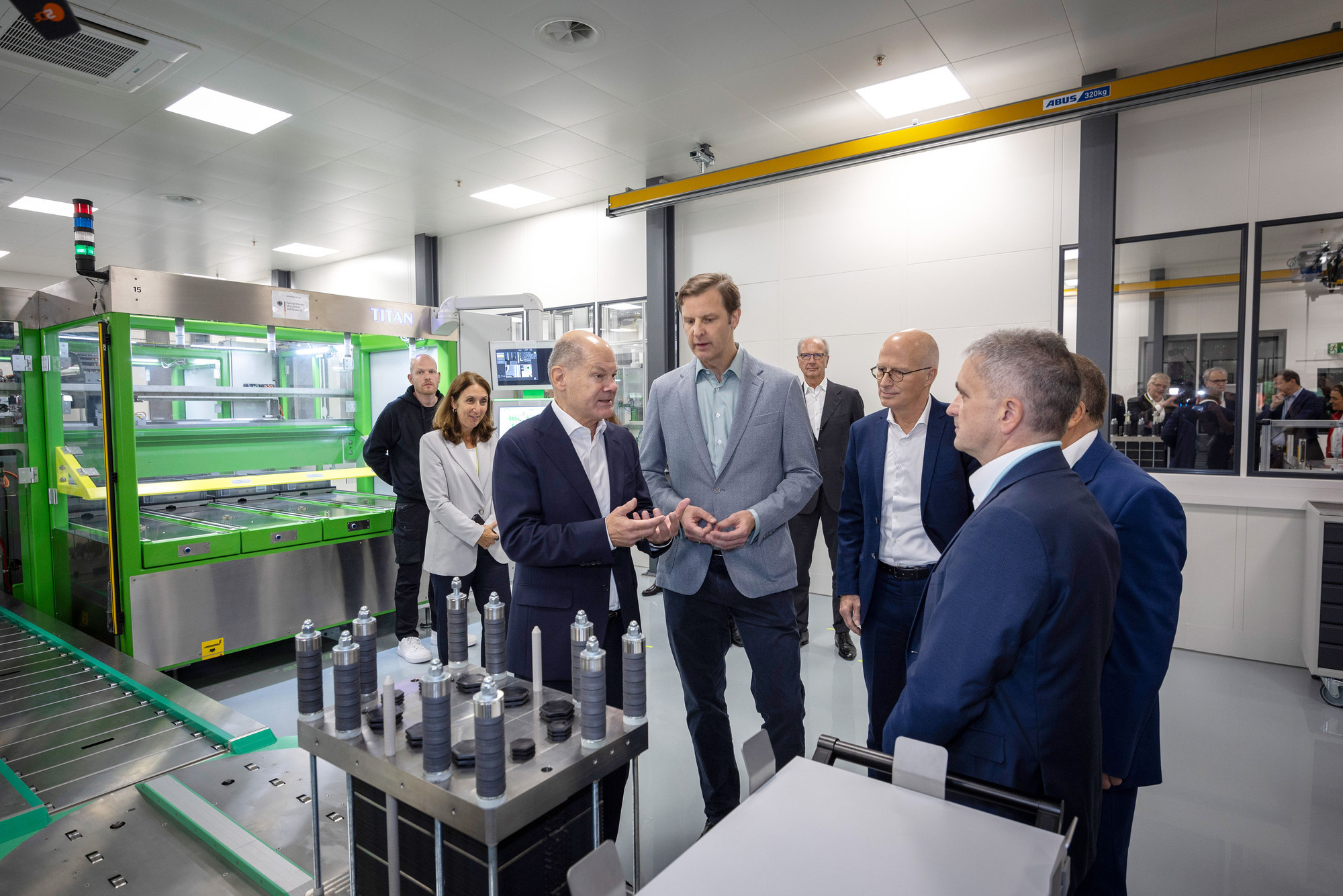 Bundeskanzler Olaf Scholz (vorne, links) besichtigt gemeinsam mit Robin von Plettenberg (CEO von Quest One, vorne, 2. Von links), Dr. Peter Tschentscher, Hamburgs Erster Bürgermeister (vorne, 3. von links) und Dr. Uwe Lauber, CEO MAN Energy Solutions (vorne, rechts) die Elektrolyse-Stack-Fertigung im Gigahub von Quest One in Hamburg. (Foto: Quest One)