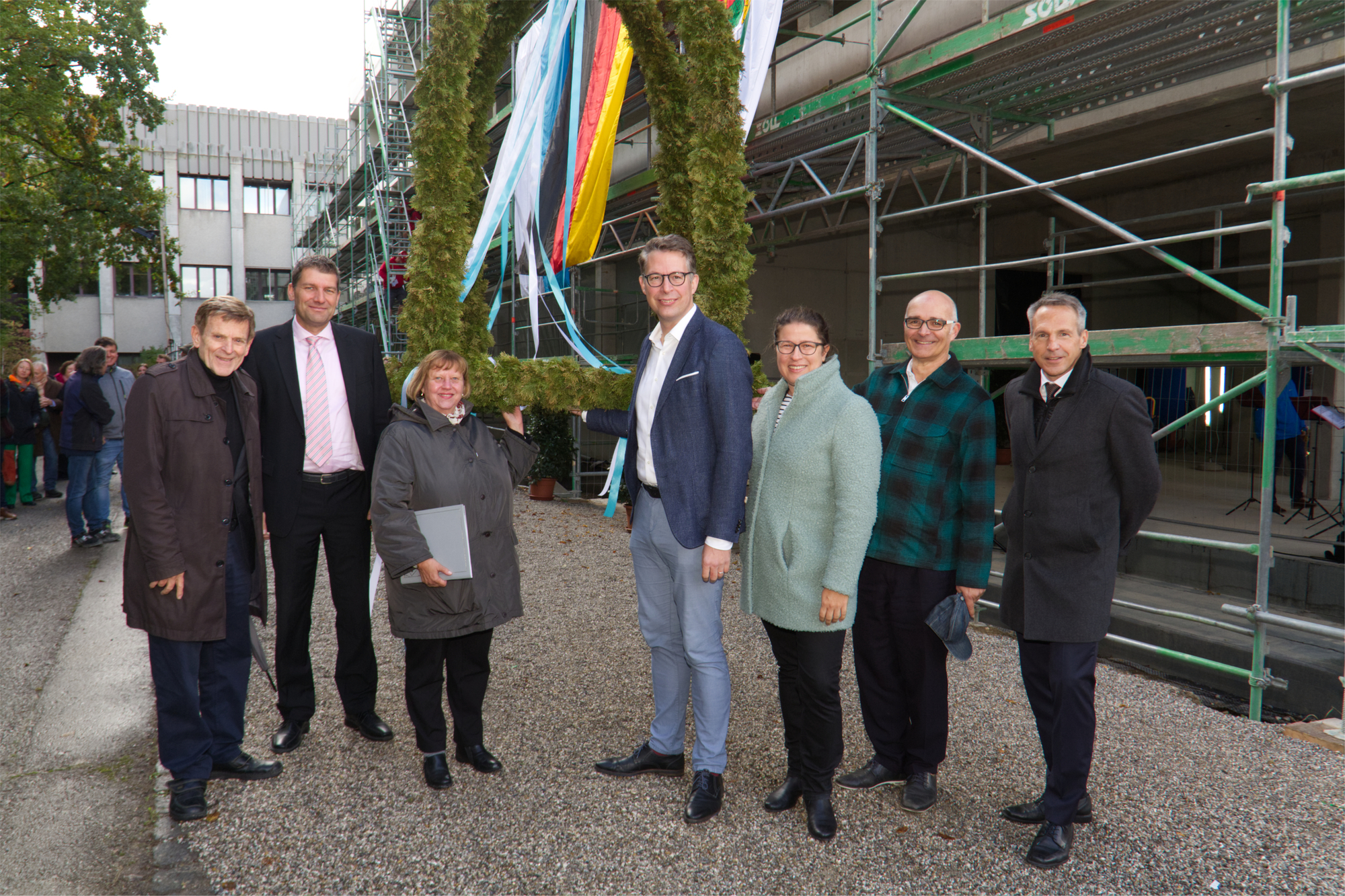 Auf dem Foto mit der Richtkrone sind von links zu sehen:3. Bürgermeister Bernd Kränzle (Stadt Augsburg), Dr. Georg Bruckmeir (Regierung von Schwaben), Prof. Sabine Doering-Manteuffel (Präsidentin der Uni Augsburg), Staatsminister Markus Blume (Bayer. Staatsministerium für Wissenschaft und Kunst), MdL Stephanie Schuhknecht, MdL Andreas Jäckel, Uwe Fritsch (Behördenleiter Staatliches Bauamt Augsburg). Foto: Christina Bleier