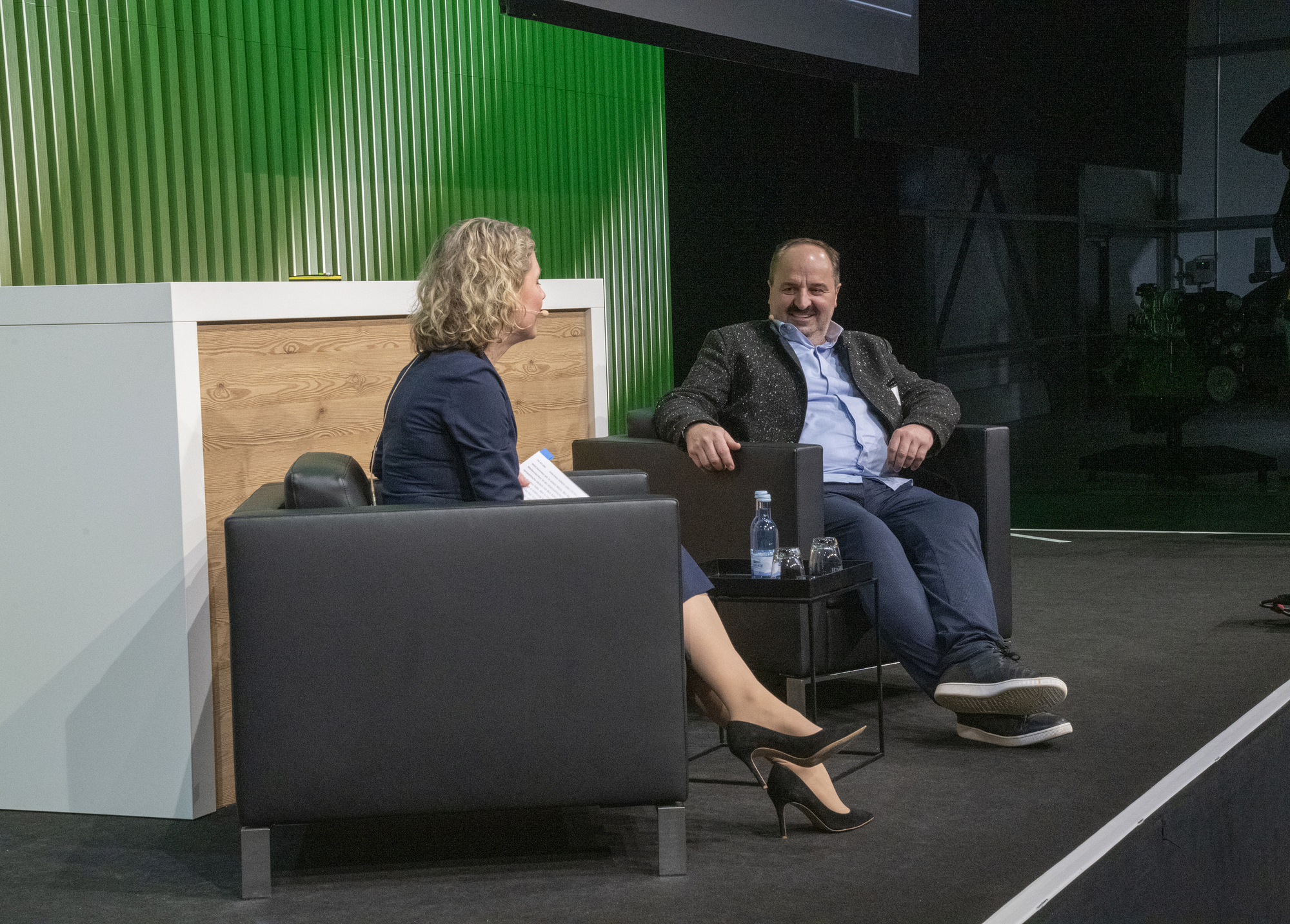 Johann Lafer (r) im Gespräch mit Manja Morawitz (Head of Public Relations &amp; Corporate Communications Fendt | l) zu seinem Werdegang vom Bauernsohn zum bekannten Koch. Foto: Fendt
