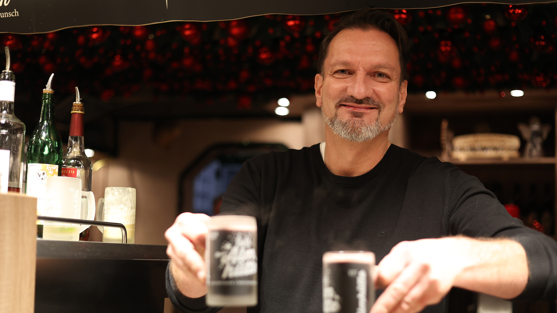FCA-Präsident Markus Krapf schenkt Glühwein auf dem Augsburger Christkindlesmarkt aus.
