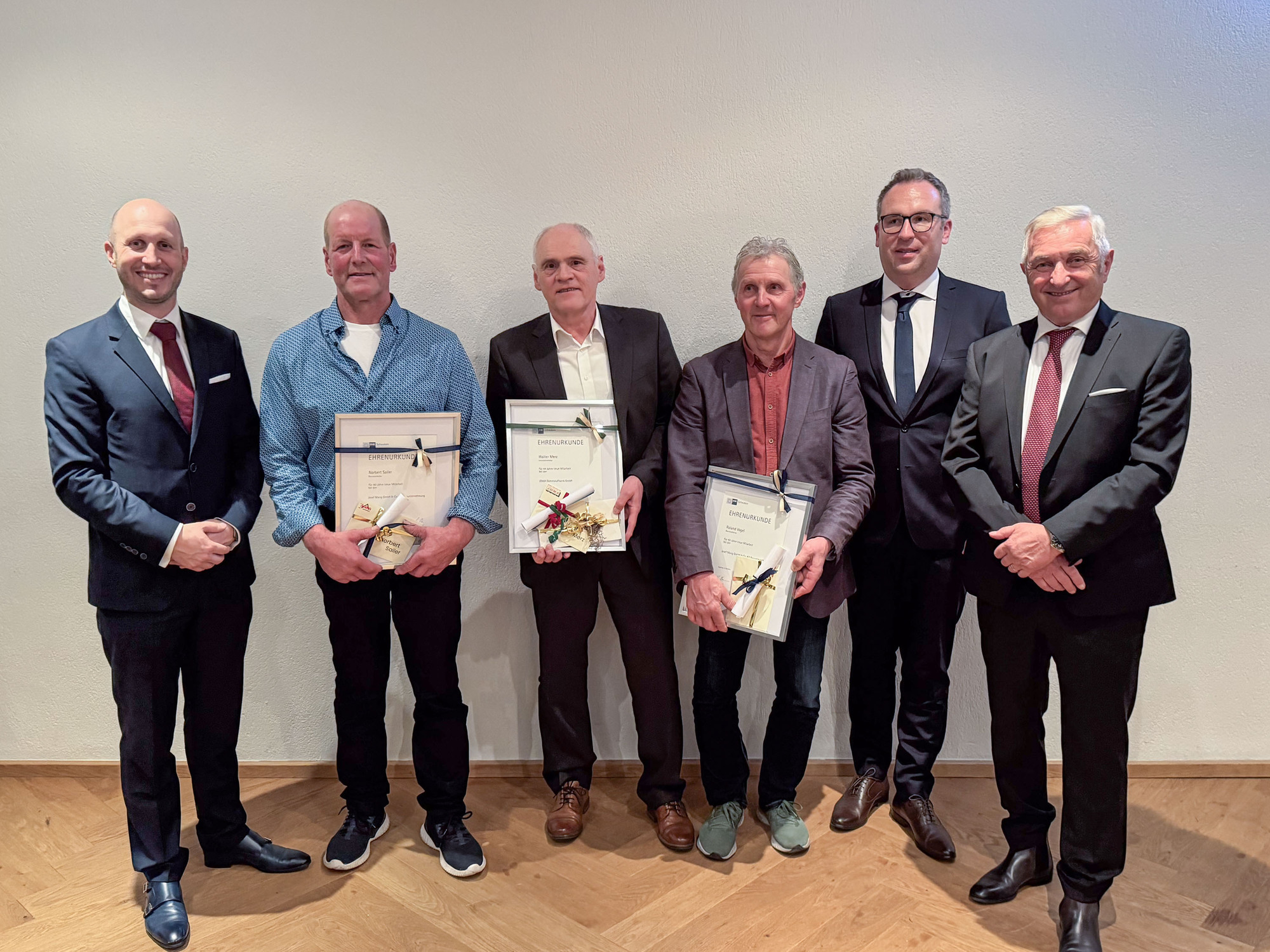 Die Jubilare mit ihren Urkunden sowie die Geschäftsführung der Mang-Gruppe.