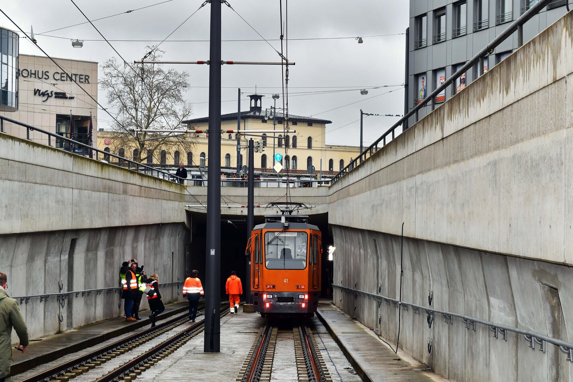 Die erste Straßenbahn, ein Schienenschleifwagen, fährt in den Straßenbahntunnel über die Rampe in der Halderstraße.
