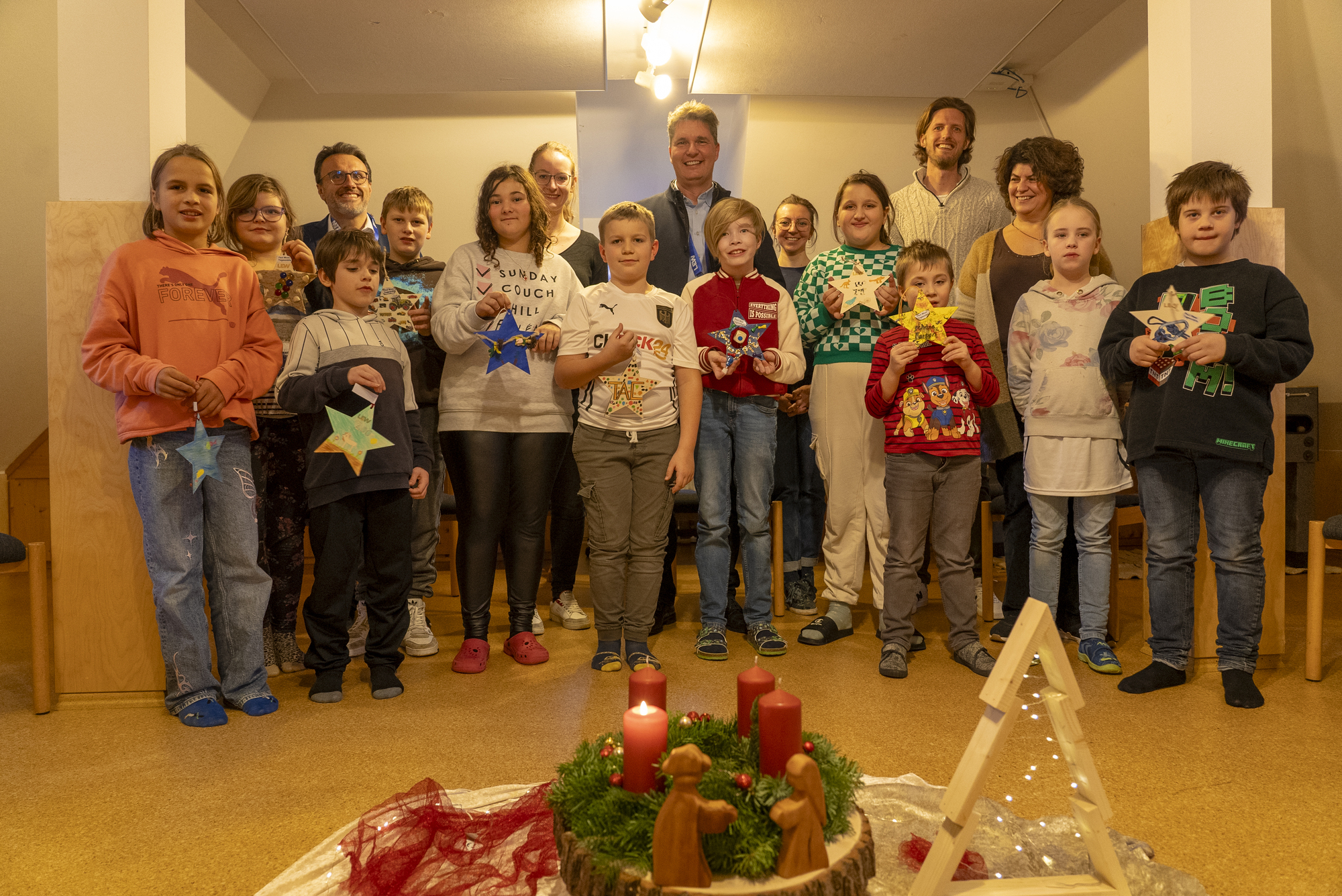 Abholung der Sterne bei der Paul-Moor-Tagesstätte der KJF Donau-Ries in Donauwörth: Kinder und Einrichtungsleiterin Vesna Milijic (mittlere Reihe rechts) präsentieren den LEW-Vertretern (hintere Reihe) ihre mit Wünschen versehenen Sterne. Bildquelle: LEW