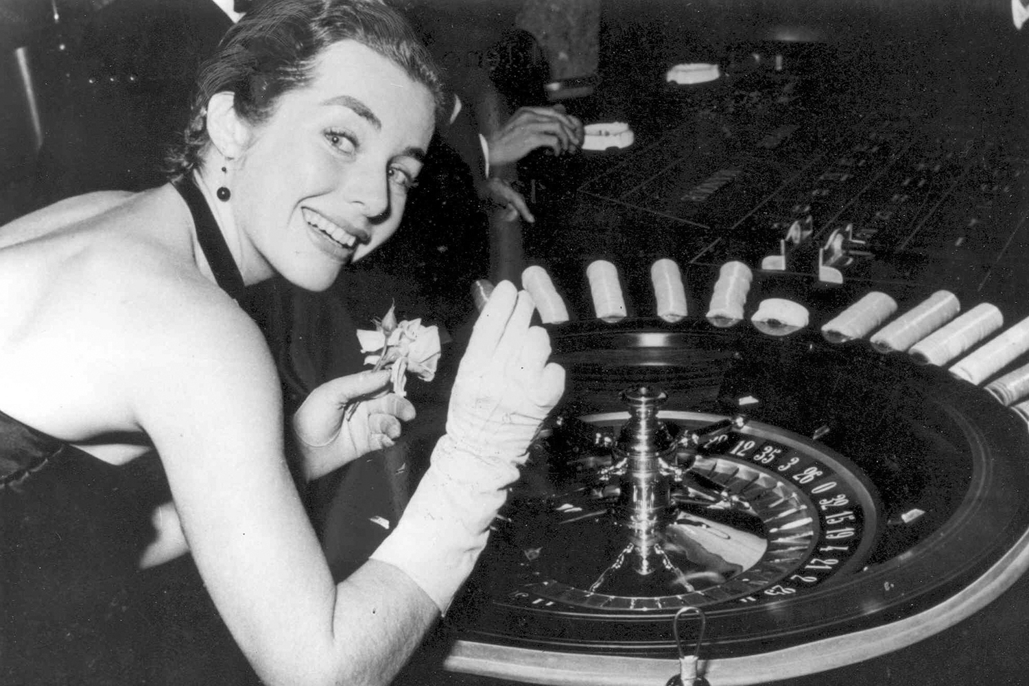 Eine fröhliche Frau spielt Roulette in einem Casino und zeigt ein strahlendes Lächeln