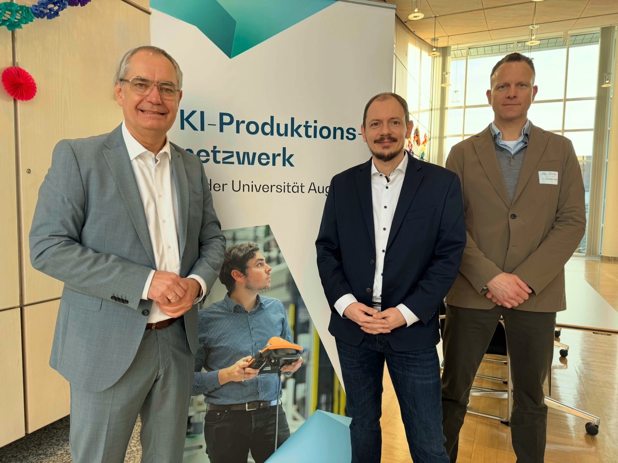 Der Erster Bürgermeister Michael Wörle (links) begrüßte Prof. Dr. Markus Sause, Direktor des KI-Produktionsnetzwerks, und Stefan