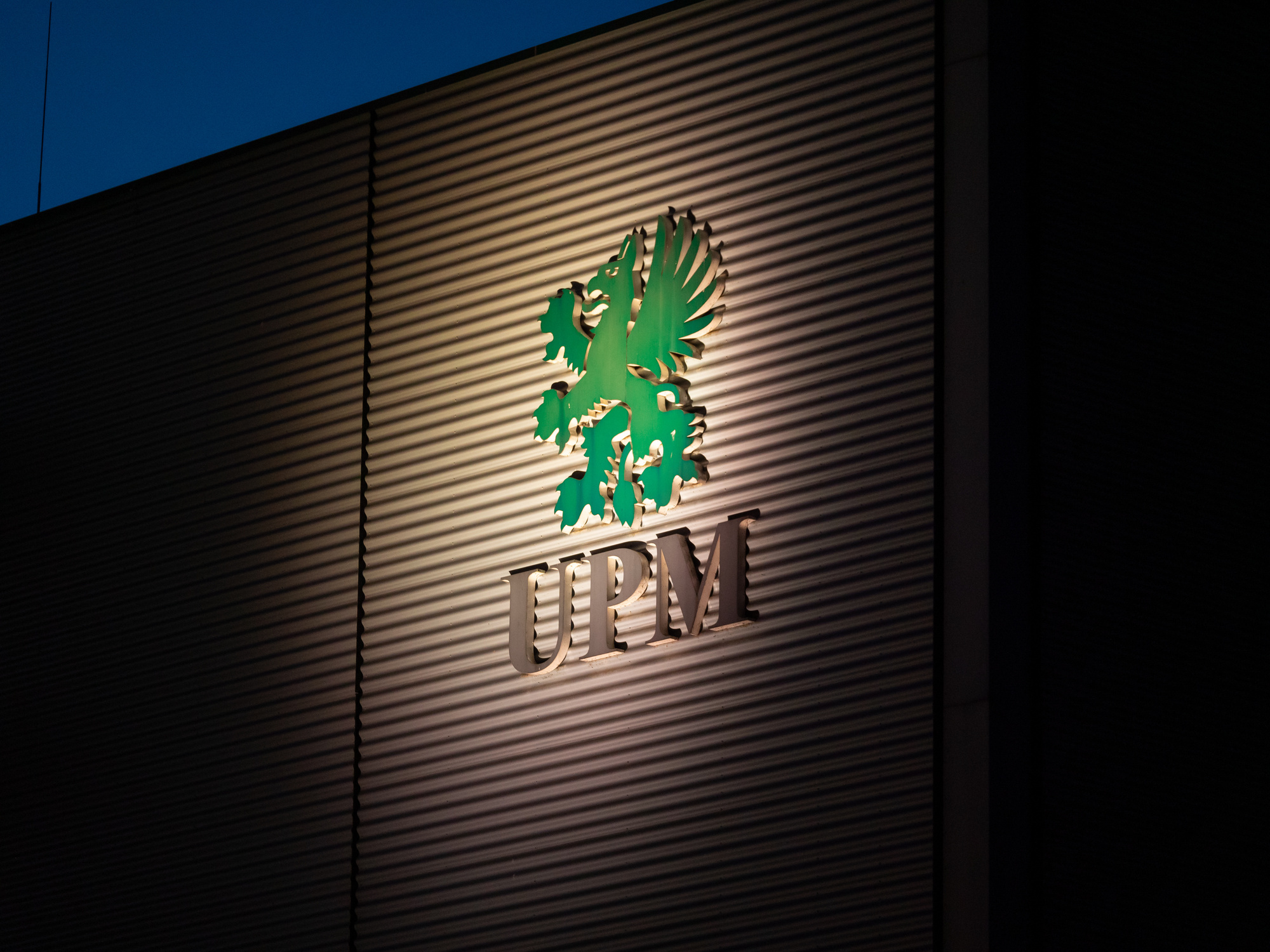 Das UPM-Logo am Werk Augsburg zu sehen bei Nacht mit Beleuchtung