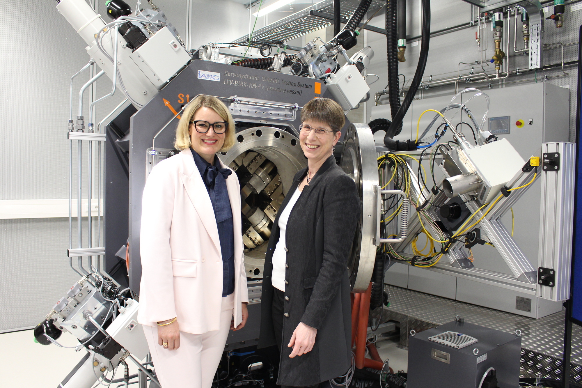 Augsburgs Oberbürgemeisterin Eva Weber (l.) und Sabine Ardey (r.), Direktorin des Instituts für Test und Simulation für Gasturbinen. Sie stehen vor einer der weltweit einzigartigen MTC-Prüfstände. Foto: B4B/ Katharina Seeburger