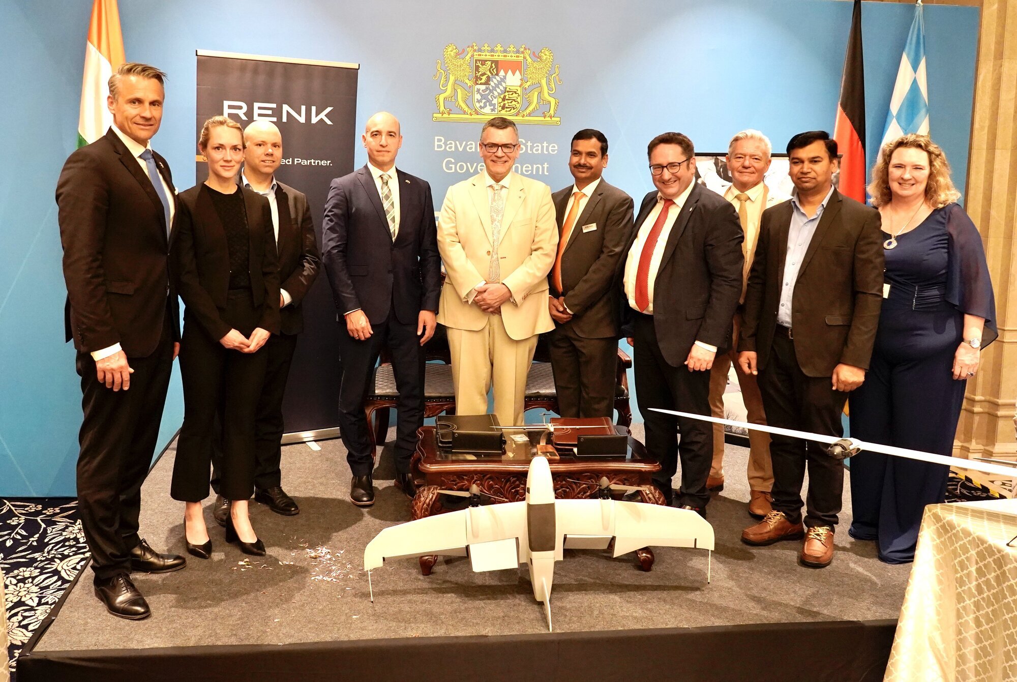 Staatssekretär Tobias Gotthardt (vierter von rechts) und Staatsminister Florian Herrmann (Mitte) bei der Unterzeichnung in Bangalore. Links und rechts von Staatsminister Herrmann die Vertreter von Quantum Systems (Martin Karkour, Chief Sales Officer) und RENK (Praveen Mohan, Geschäftsführer RENK India). Foto: StMWi
