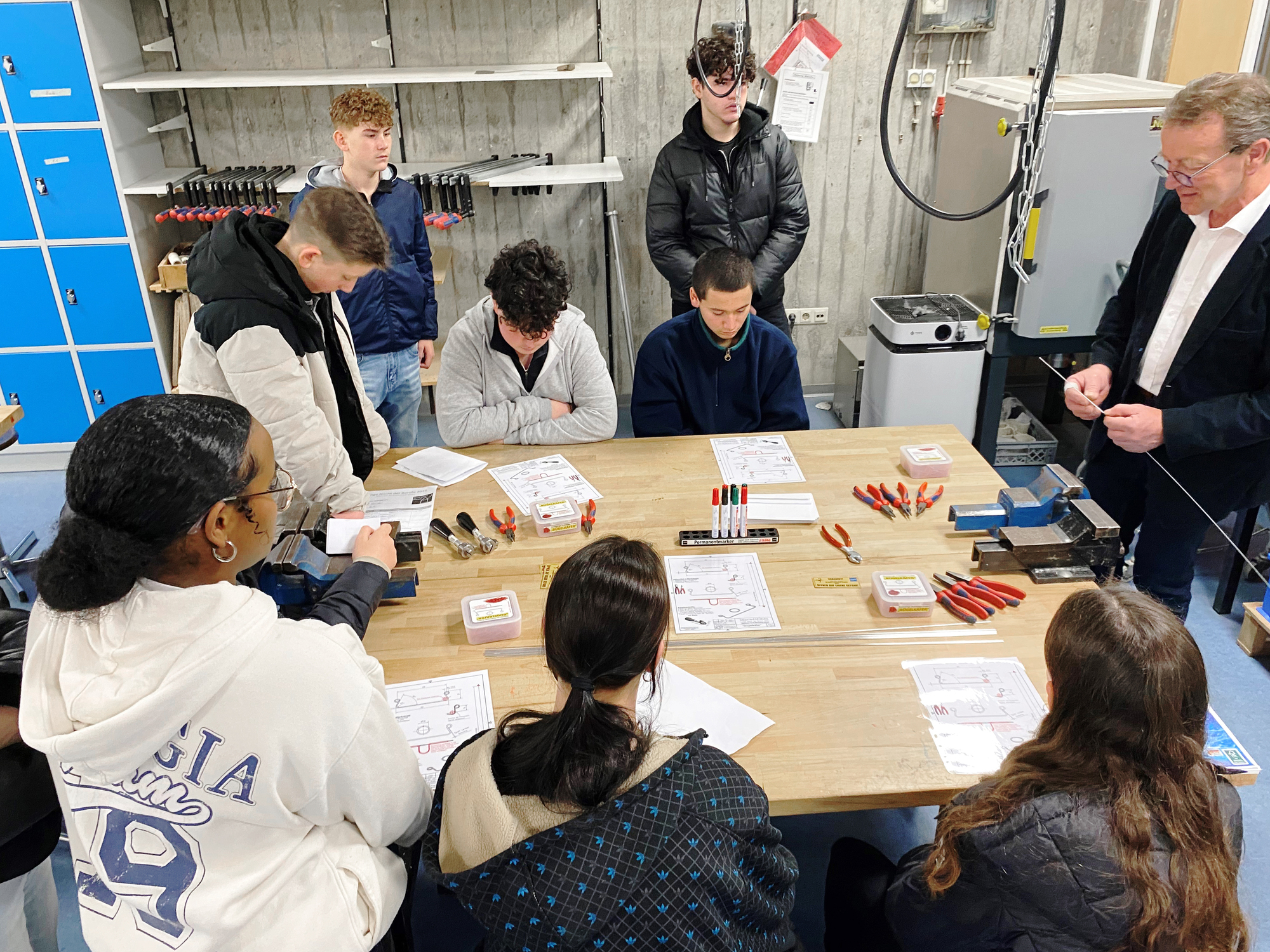 Schülerinnen und Schüler haben im Metallworkshop unter Anleitung von Ausbildungsmeister Ludwig Regau ein Werkstück bearbeitet. Foto: Haimer GmbH
