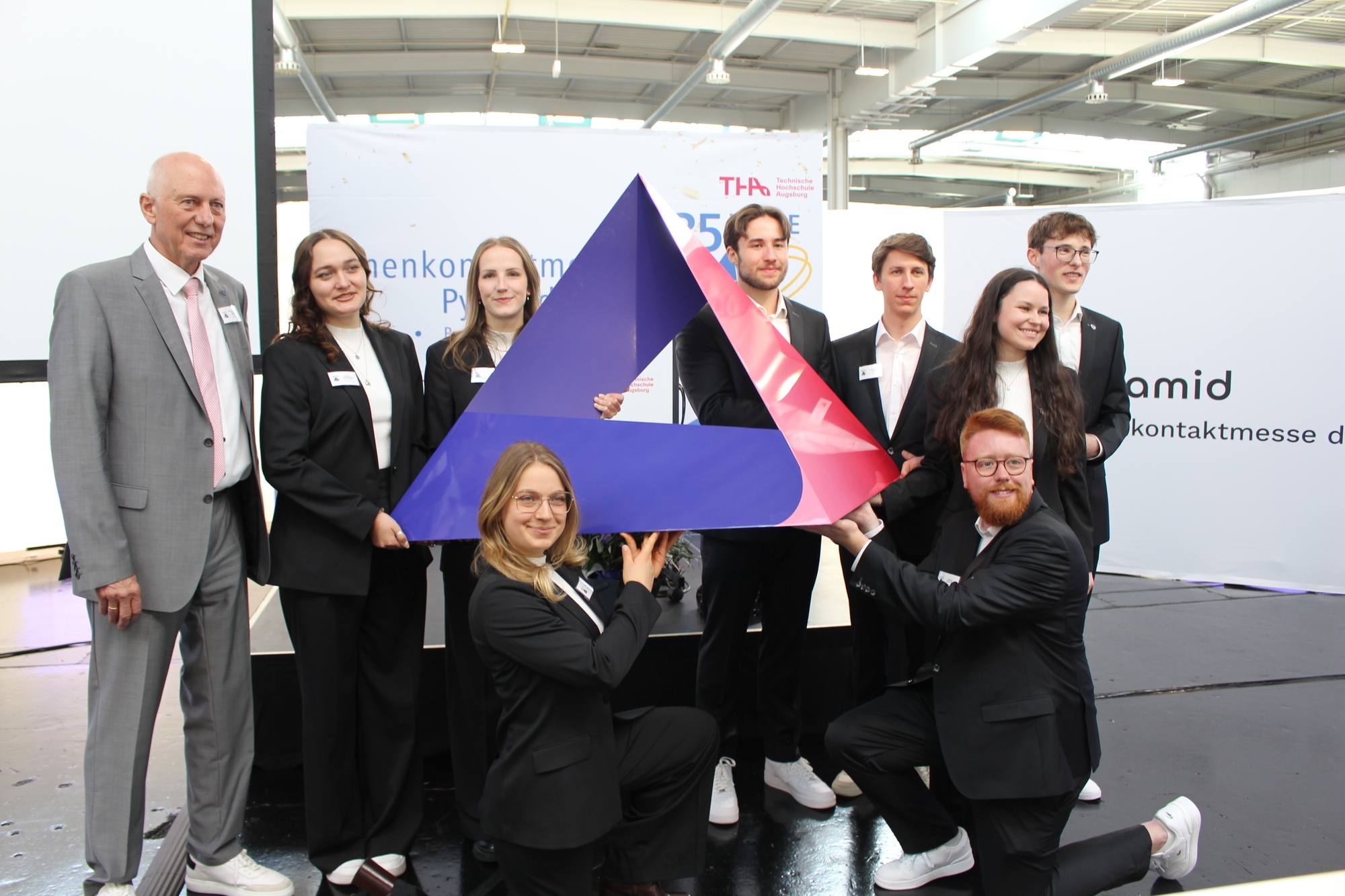 Das neue Logo der Firmenkontaktmesse Pyramid. Das Leitungsteam: Hintere Reihe: v. l. n r.: Prof. Dr. habil. Klaus Kellner, Marina Ullersperger, Ines Orthofer, Sebastian Wolk, Johannes Knoll, Irina Gross und Felix Helmprecht. Vordere Reihe v. l. n. r.: Luisa Honal und Jeffrey Johnson. Foto: B4B/ Katharina Seeburger