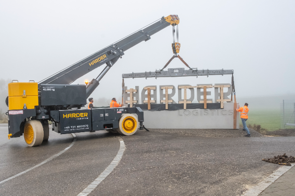 Der firmeneigene Industriekran war im Einsatz, um den 13 t schweren Schlussstein, der auf sieben Meter Länge den Firmennamen zeigt, in Position zu bringen. Foto: Ulli Schlieper