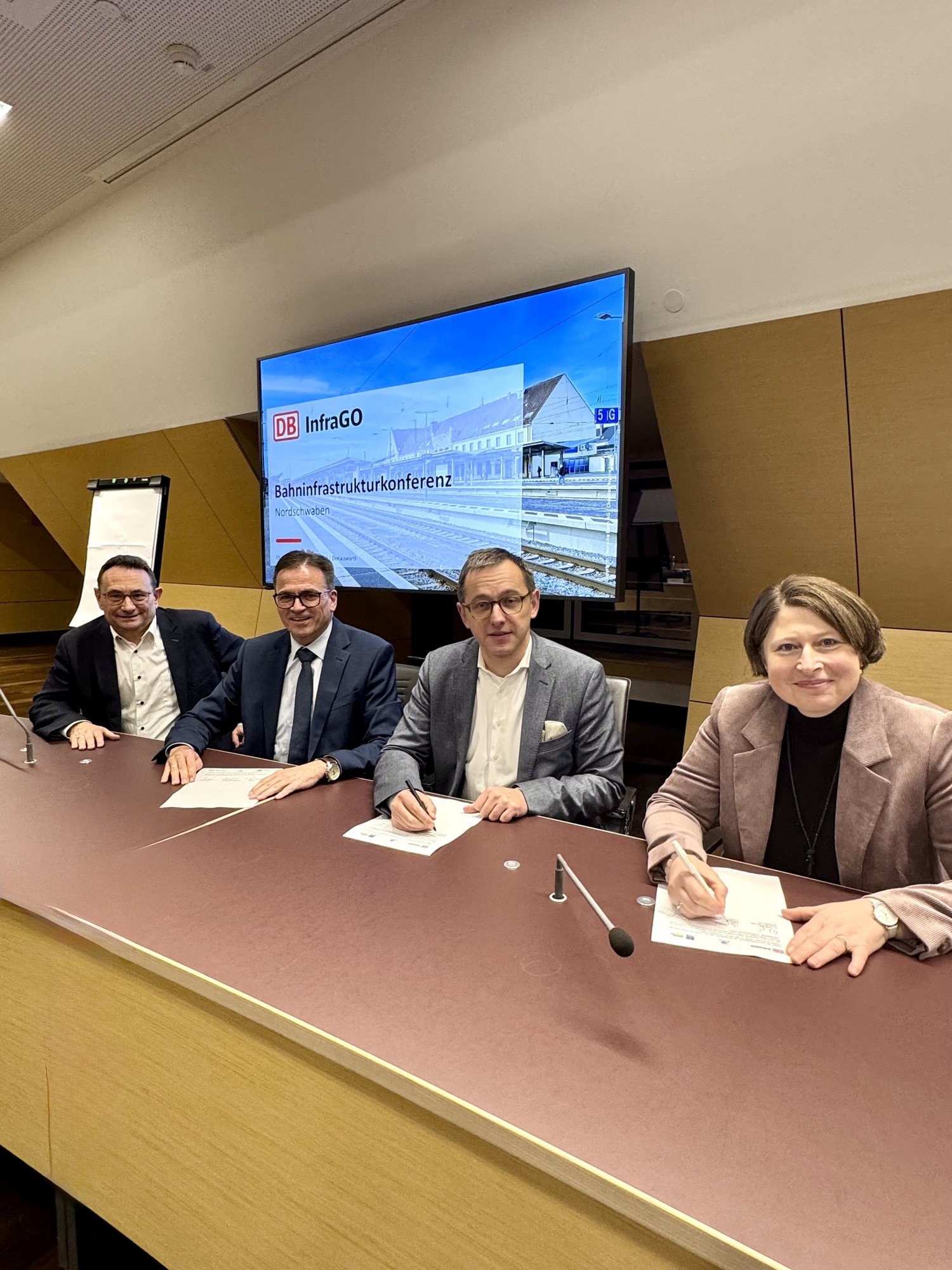Die Unterzeichnung der Absichtserklärung bei der Bahnkonferenz in Donauwörth. Von links: Bundestagsabgeordneter Ulrich Lange, Joachim Bläse (Landrat Ostalbkreis), Philipp Nagl (Vorstandsvorsitzender DB InfraGO AG) und Claudia Marb (Stellvertreterin des Landrats, Landkreis Donau-Ries). Foto: Büro Ulrich Lange MdB