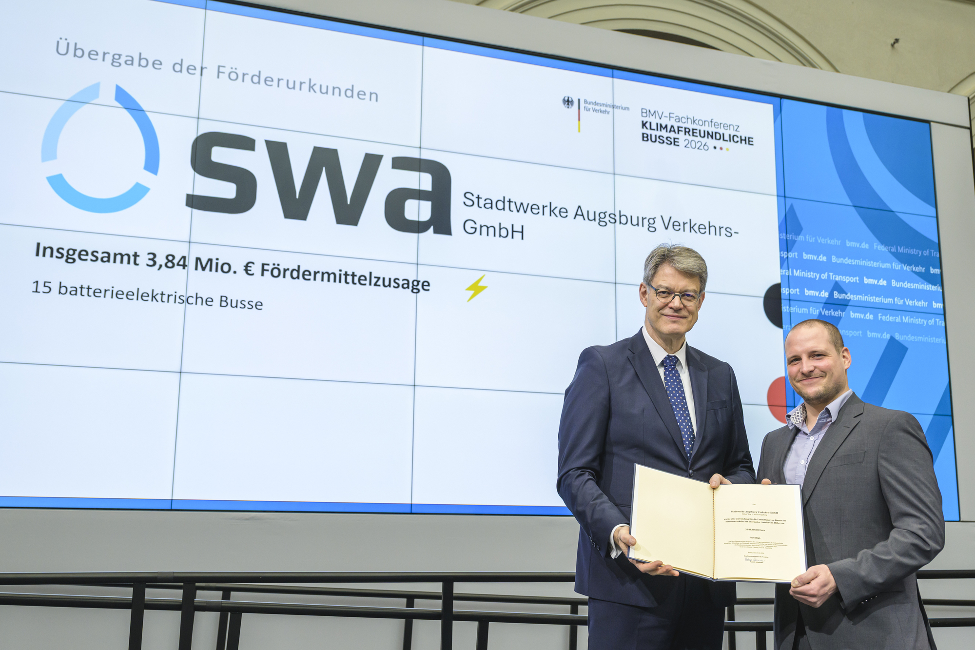(v.l.n.r.:) Patrick Schnieder, Bundesminister für Verkehr, übergibt Johannes Jung, swa-Projektleiter Einführung E-Mobilität Bus die Förderurkunde für 15 batterieelektrische Busse. Fotos: Frank Schroth Fotografie