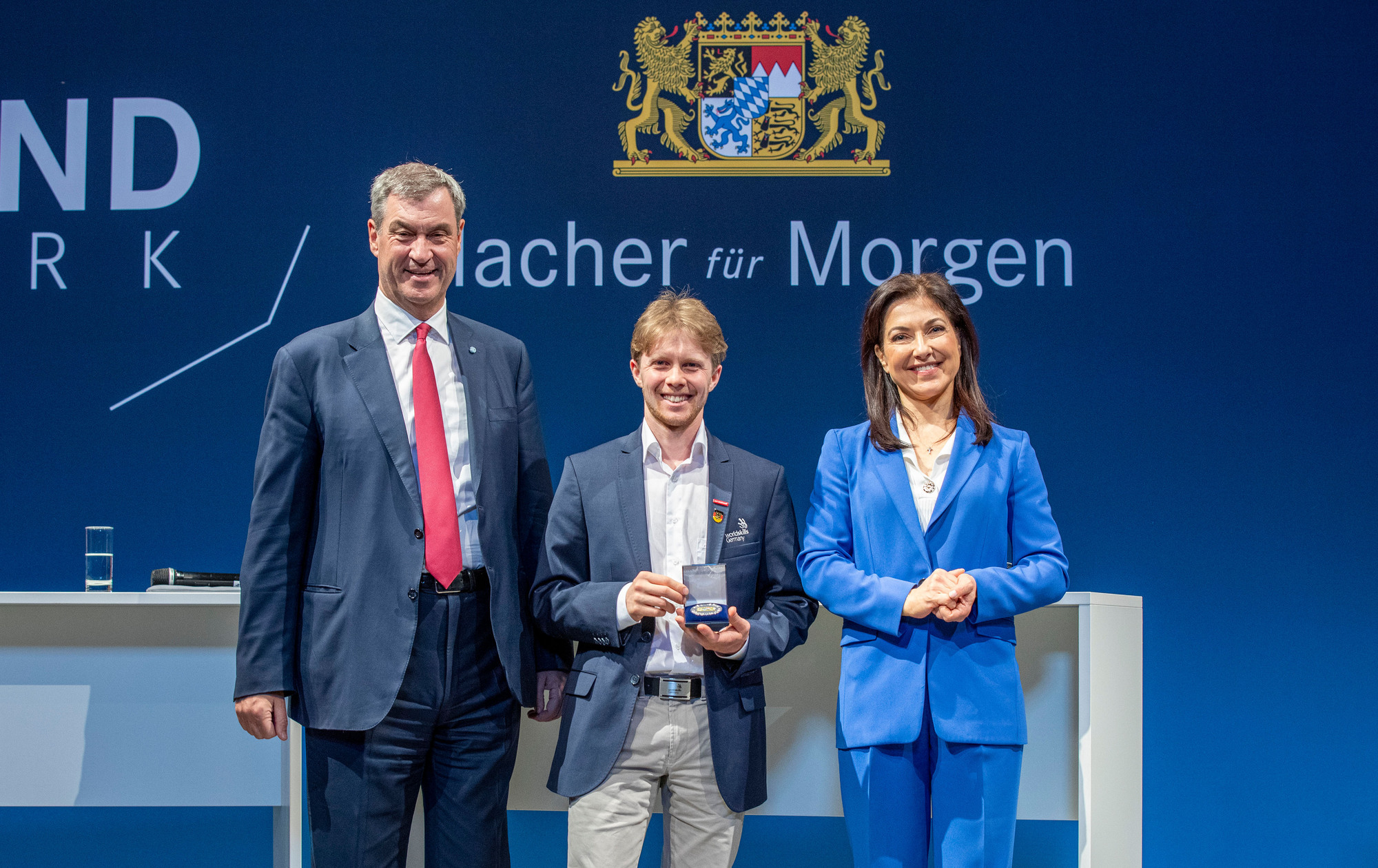 Schreiner Moritz Wagner mit Ministerpräsident Markus Söder und Bundeswirtschaftsministerin Katherina Reiche. Foto: HWK