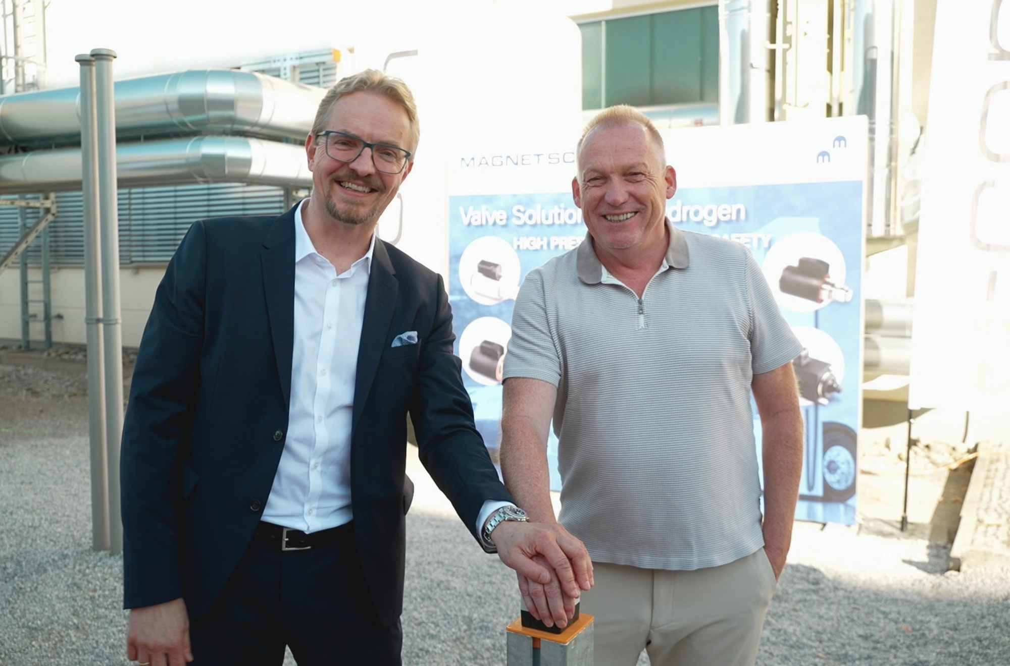 Dr. Albert Schultz, Geschäftsführer von Magnet-Schultz (links), und Andreas Müller, geschäftsführender Gesellschafter der Alois-Müller-Gruppe, nehmen den Fernwärmeanschluss am Memminger Hauptstandort symbolisch in Betrieb. Foto: e-con AG